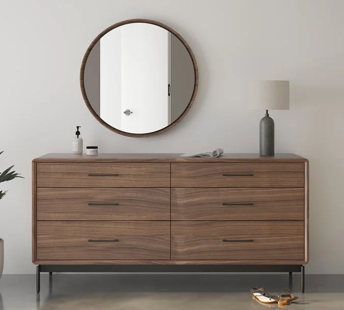 LINQ round mirror centered above mid-century modern dresser in minimalist bedroom setting