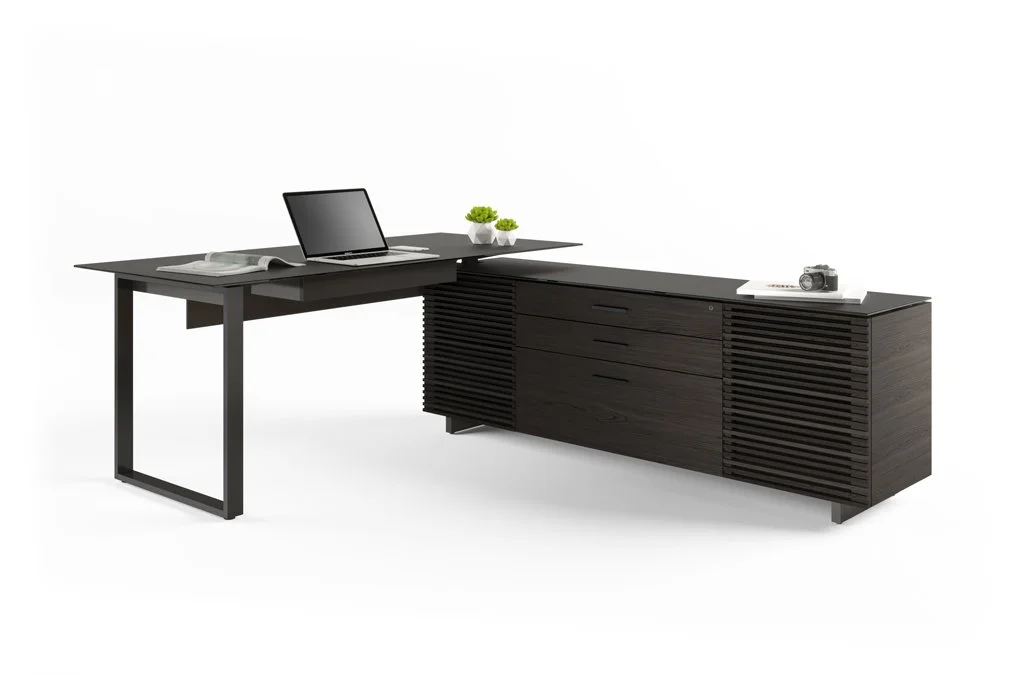 Corridor L-Desk in black with laptop, lamp, and accessories set up in modern workspace