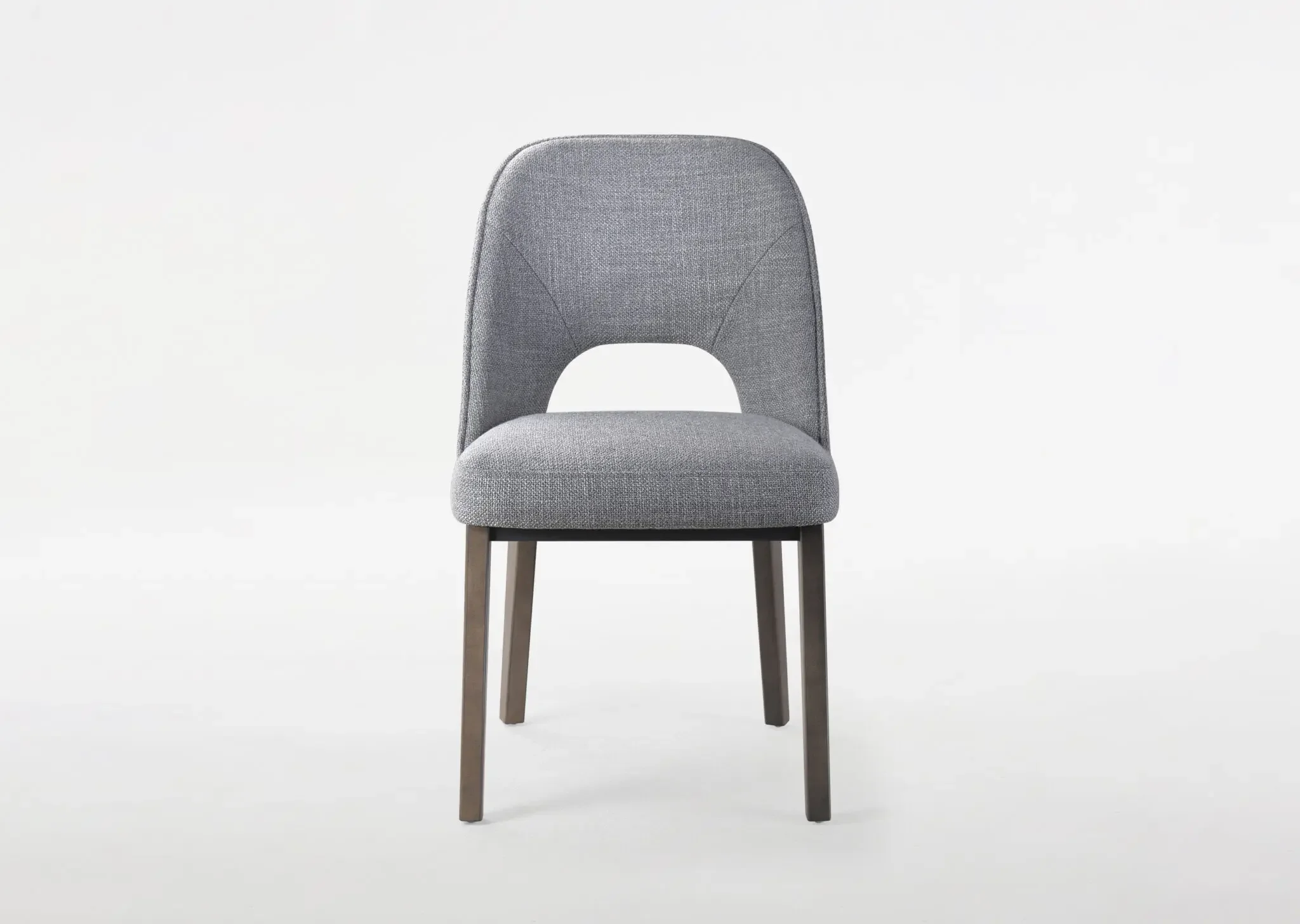 Angled front view of Trica Mia Dining Chair with wood legs and modern silhouette