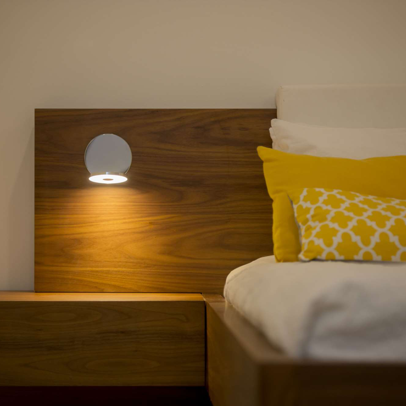 Gravy Wall Sconce mounted above bed in modern bedroom