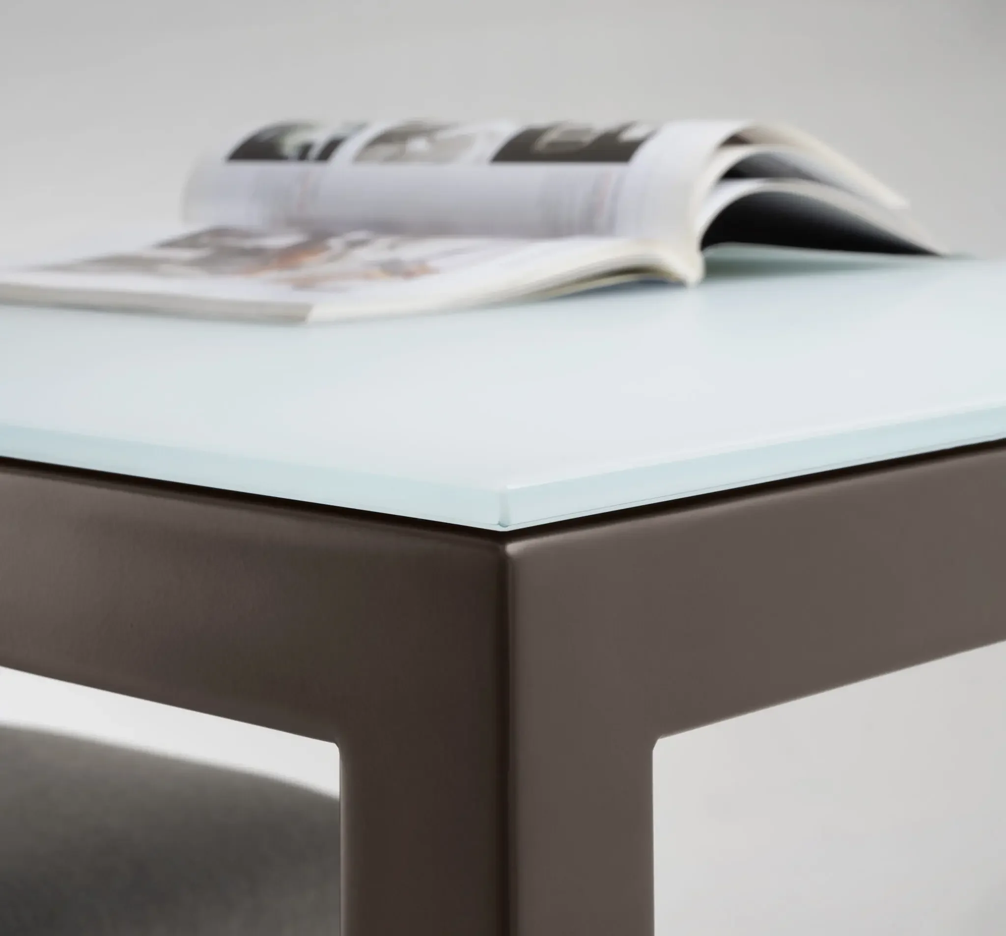 Close-up of Trica Cubo Counter-height Table corner showing glass top and metal frame detail
