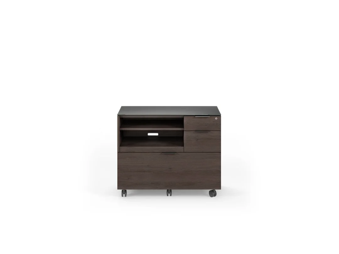 Angled view of Sigma multifunction cabinet in dark wood finish on casters