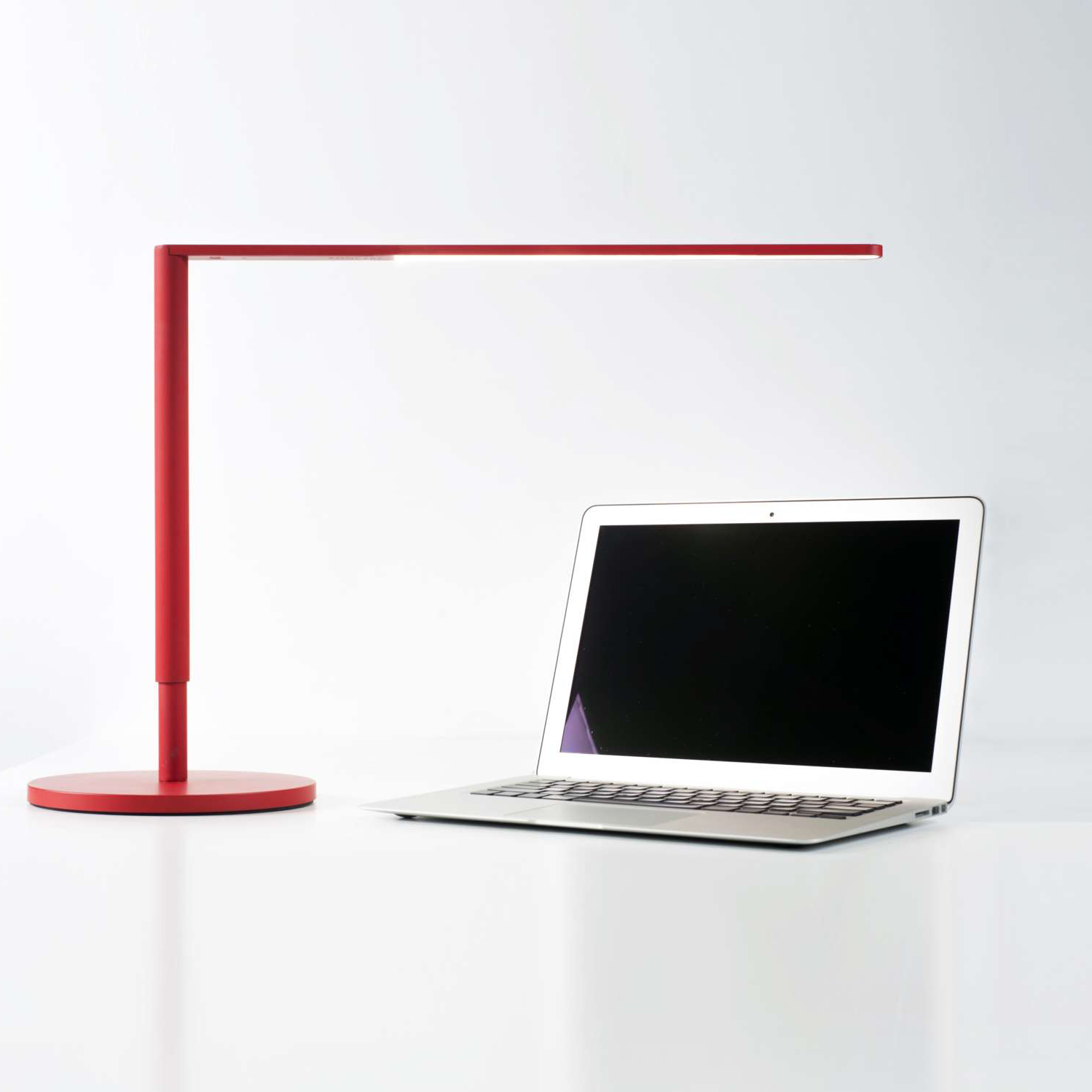 Red Lady 7 Desk Lamp on desk beside laptop