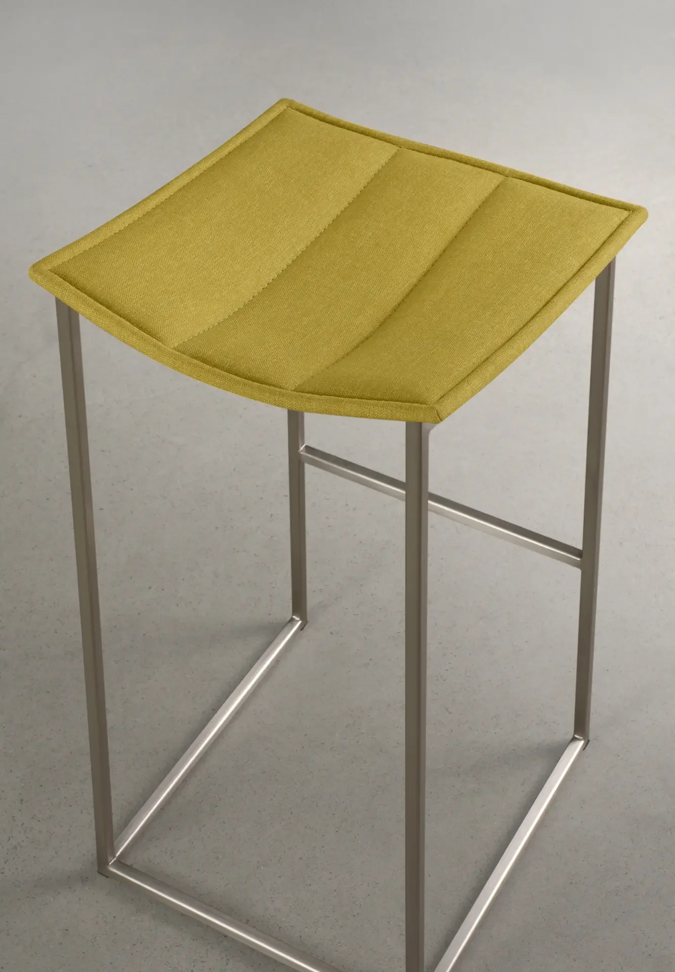 Trica Bocca Counter Stool with yellow upholstered seat and stainless steel frame, angled view