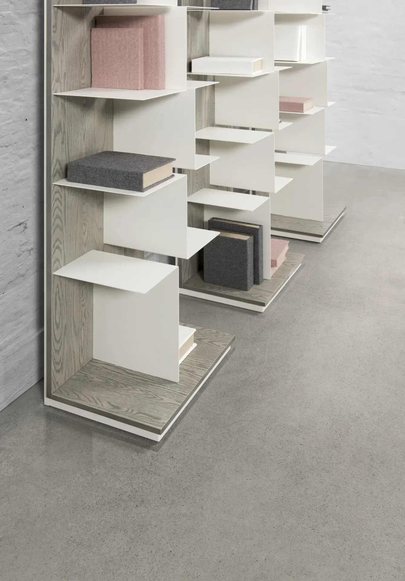 Two Trica Maze Shelving Units in light finish with white shelves, styled with books and décor in modern room