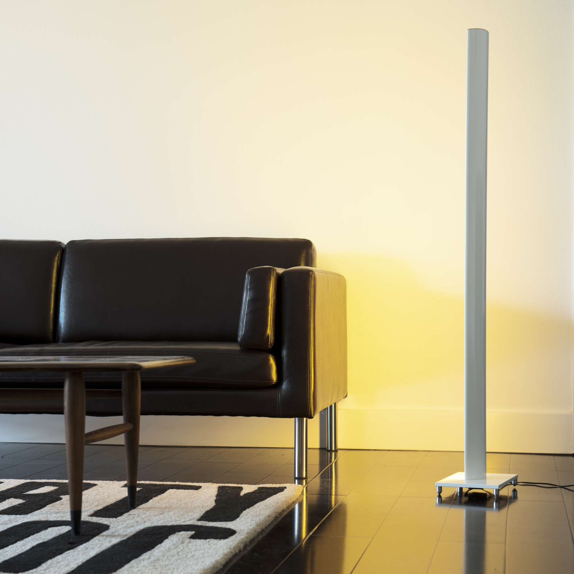 Koncept Tono Mood Light set to warm white glow beside sofa