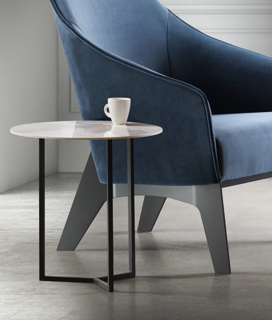 Tam-Tam Cocktail Table beside a blue lounge chair with coffee cup