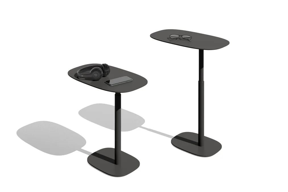 Height-adjustable black Serif tables with headphones and tech accessories displayed