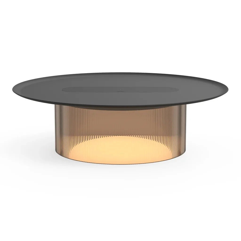 Modern living room with Pablo Carousel Table Lamp glowing at night