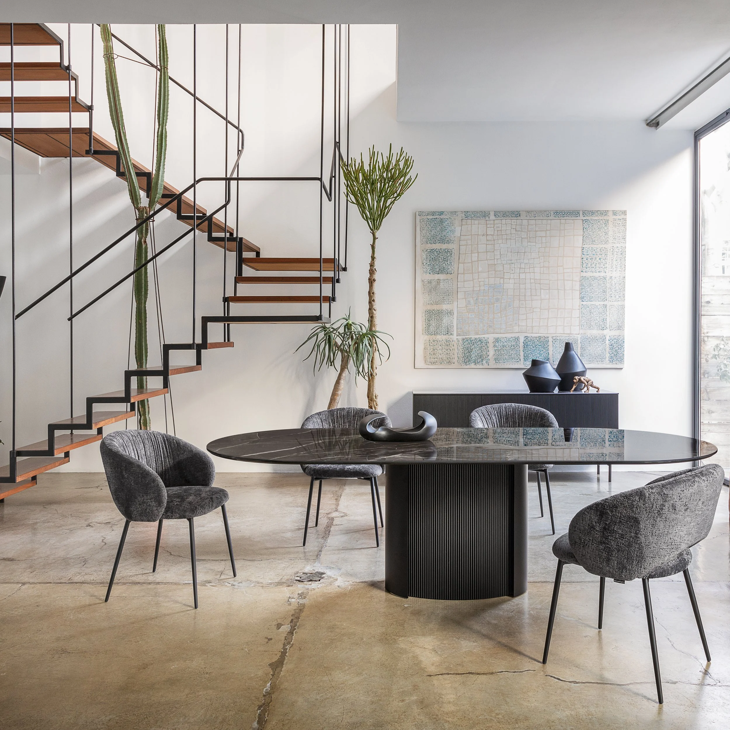 Set of Anime Dining Chairs around a modern round dining table in a bright open-plan room