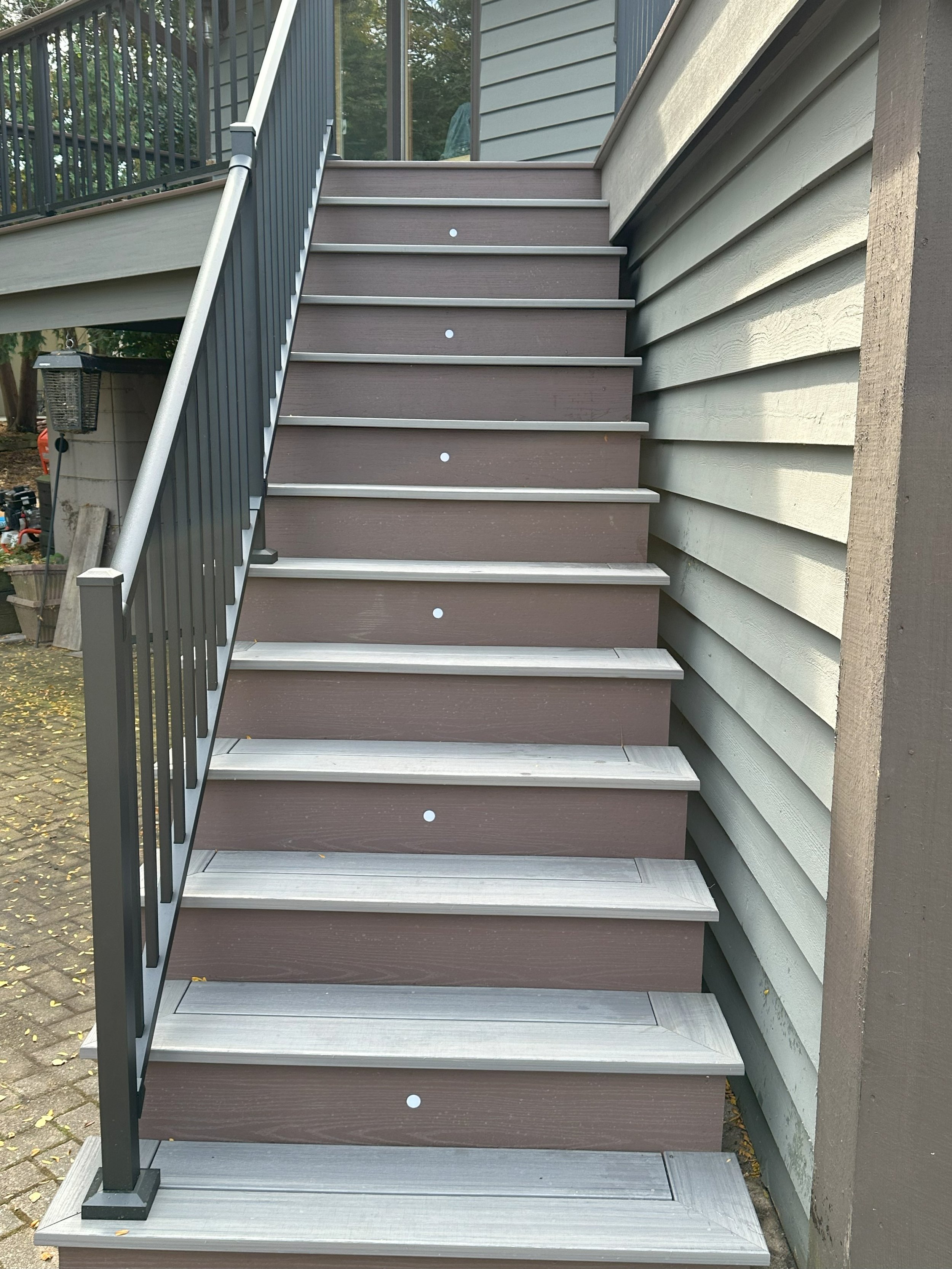 Outdoor wooden stairs with railing leading to a deck.