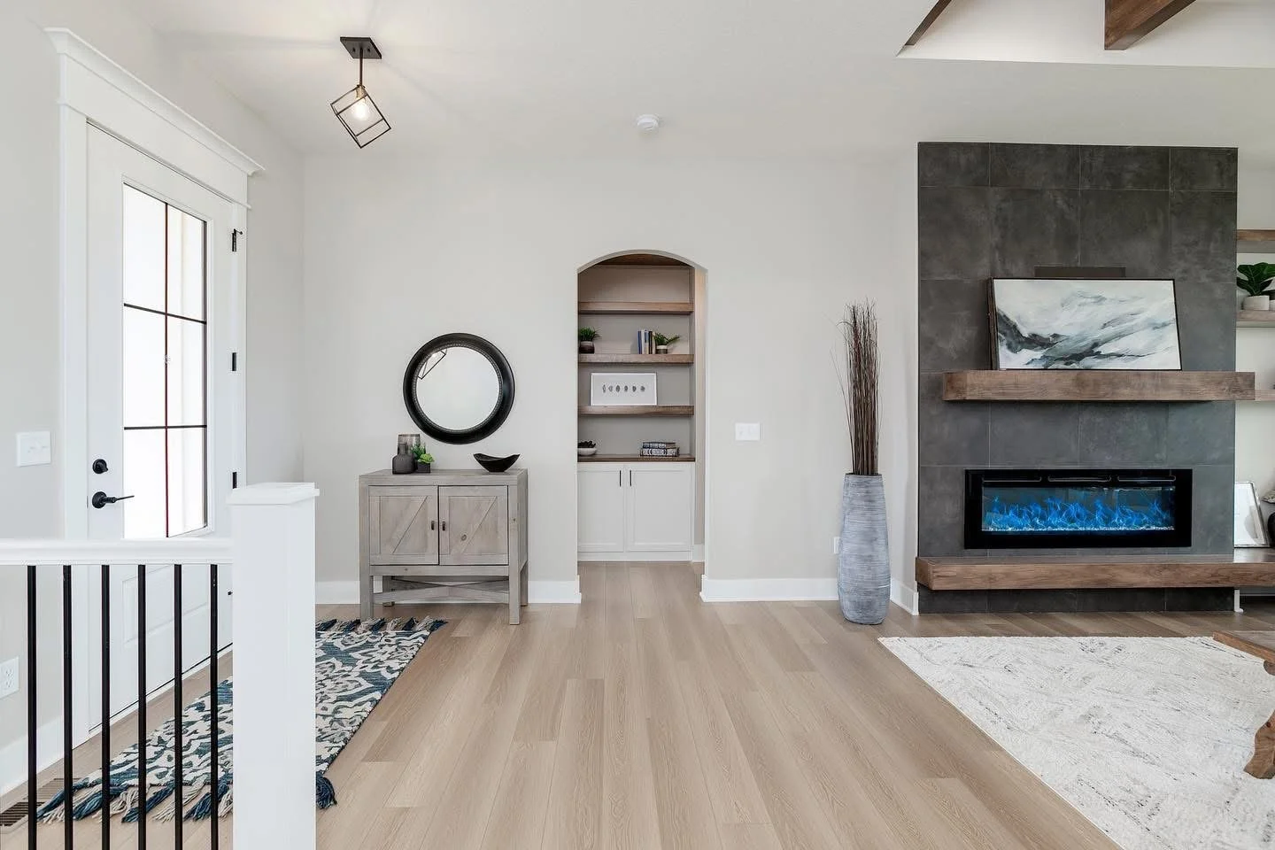 Living room with modern decor, fireplace, built-in shelves, and a window with a grid pattern.