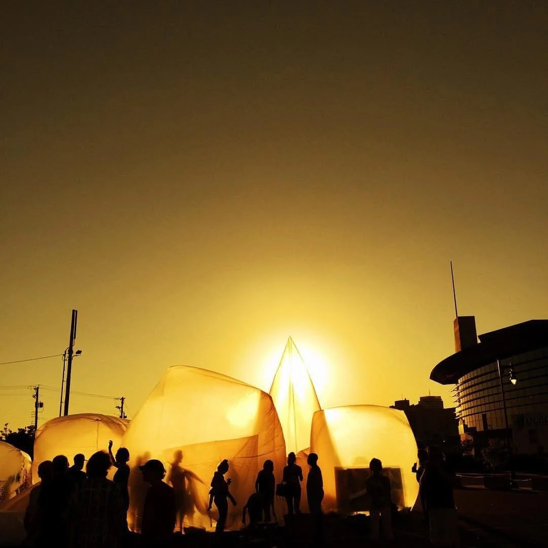 People releasing sky lanterns during a sunset or sunrise.