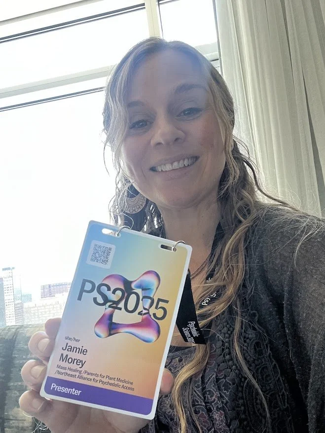 Jamie Morey holding a conference badge with the text 'PS2055' and her name 'Jamie Morey' in front of a window.