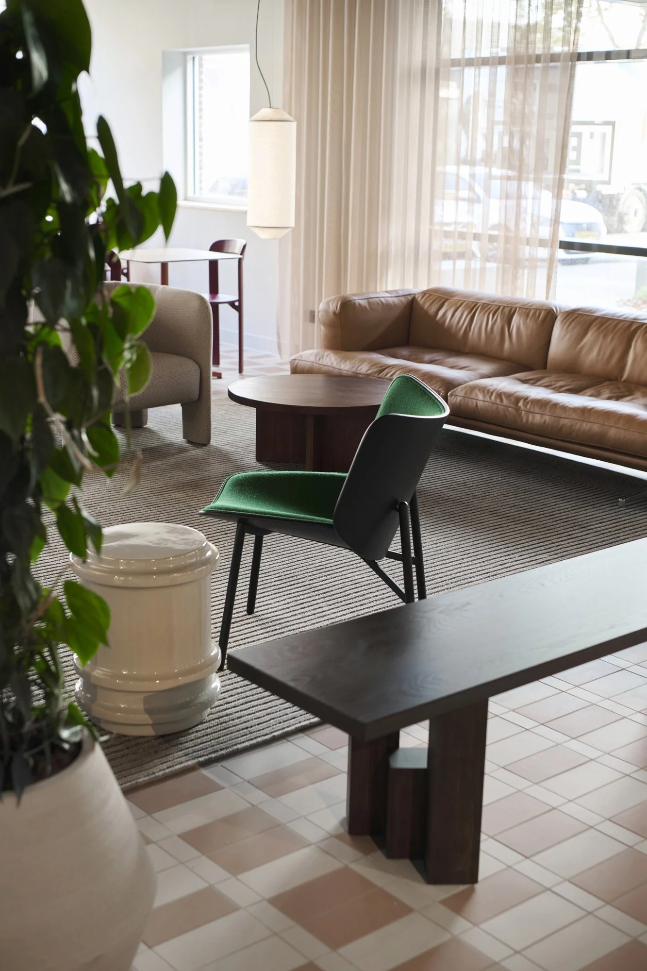 Low seating area with green lounge chair in KBF Warehouse lobby, Amsterdam. Designed by Meeder Ontwerpers