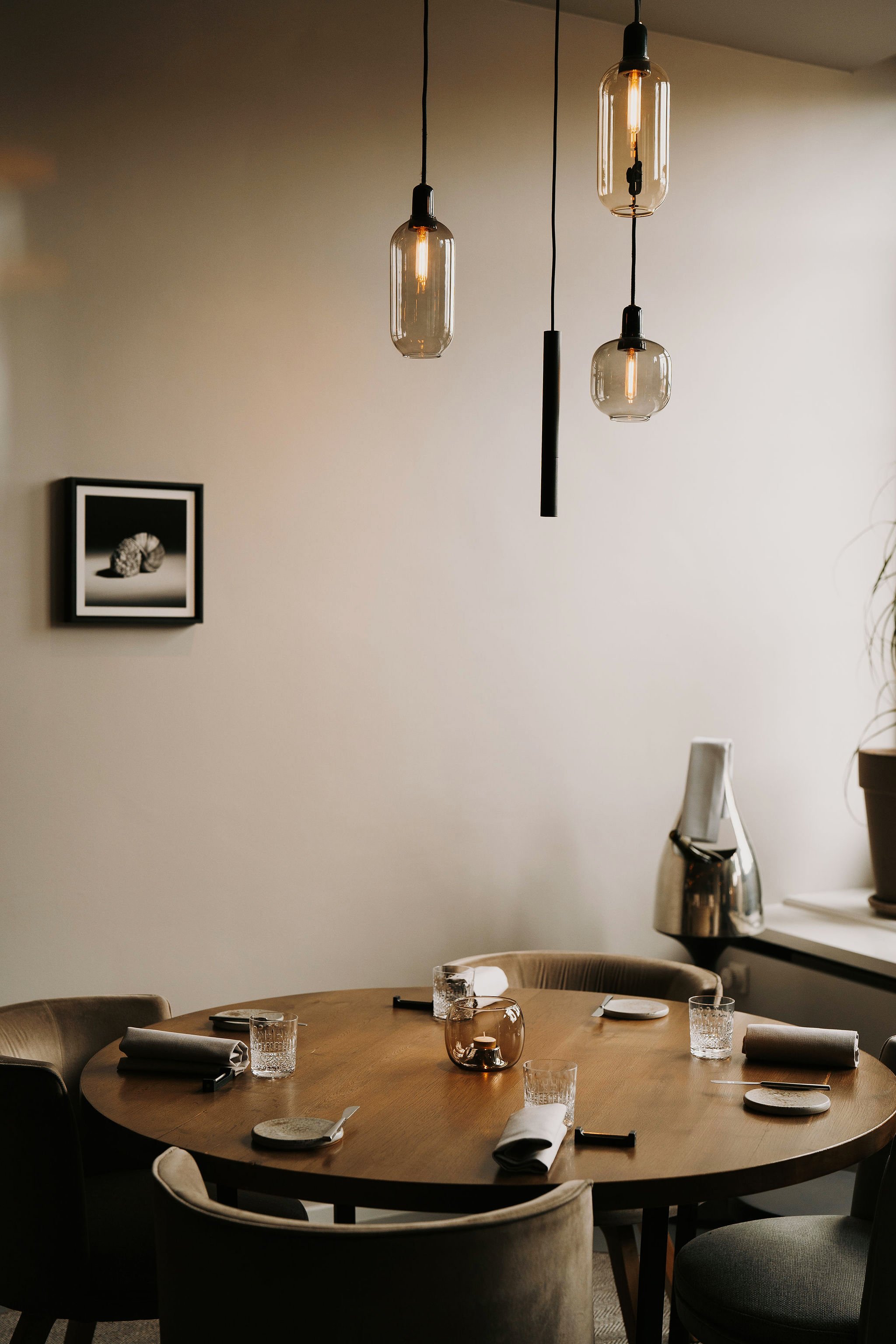 Round dining table with black and white shell artwork at Restaurant Vermeer, Amsterdam, redesigned by Meeder Ontwerpers