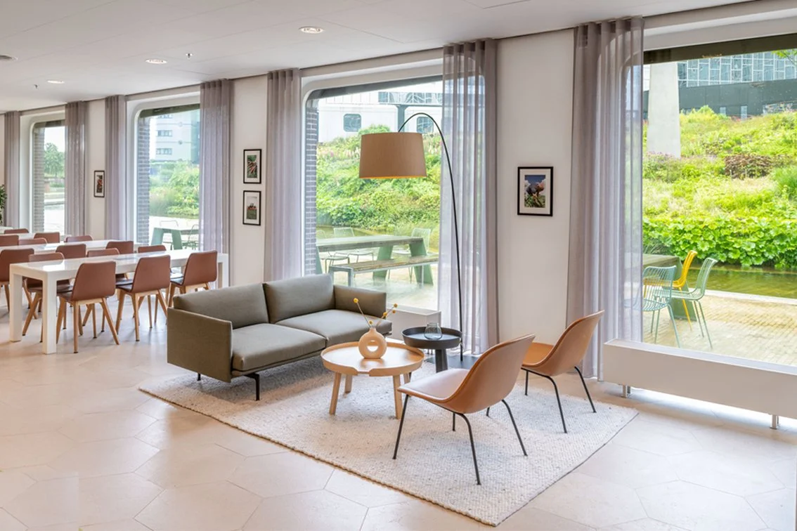 Lounge area with view over water and garden at The Tasting Room, Rabobank Headquarters Utrecht, designed by Meeder Ontwerpers X OIII Architecten.