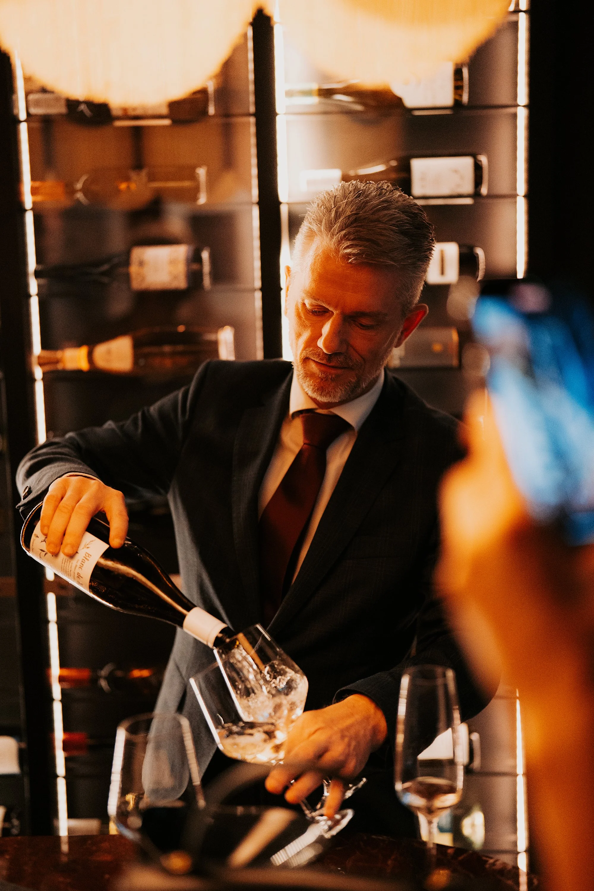 Waiter pouring wine at Vermeers Wijnkamer, NH Barbizon Palace Amsterdam, redesigned by Meeder Ontwerpers X Studio Michiel Wijnen.