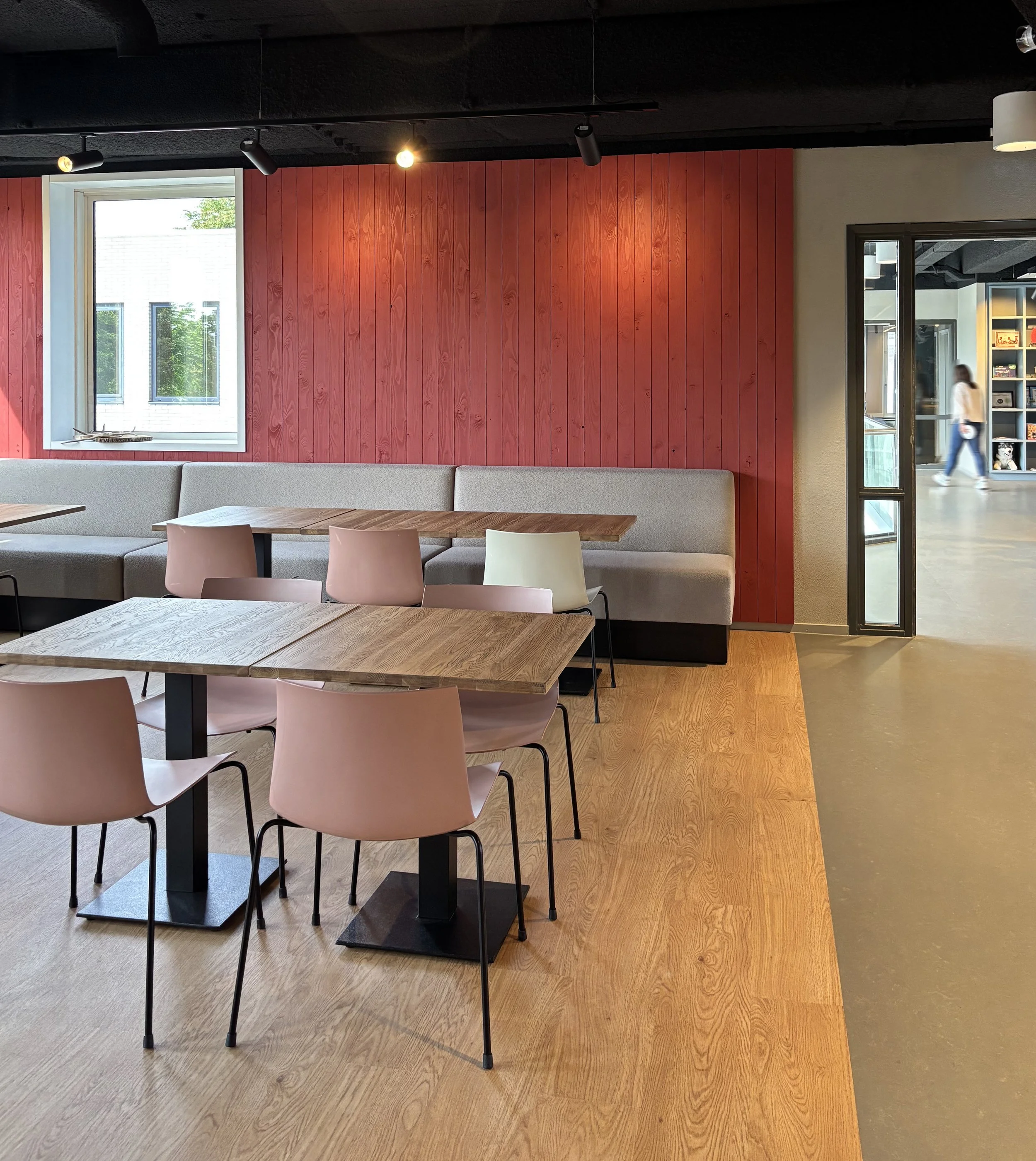 Canteen with red wooden wall and pink chairs at Northbound Travel office, Naarden, designed by Meeder Ontwerpers.