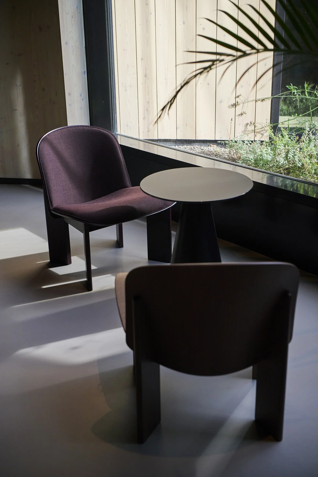 Low seating area with HAY Chisel chairs on patio at KBF Warehouse, Amsterdam.