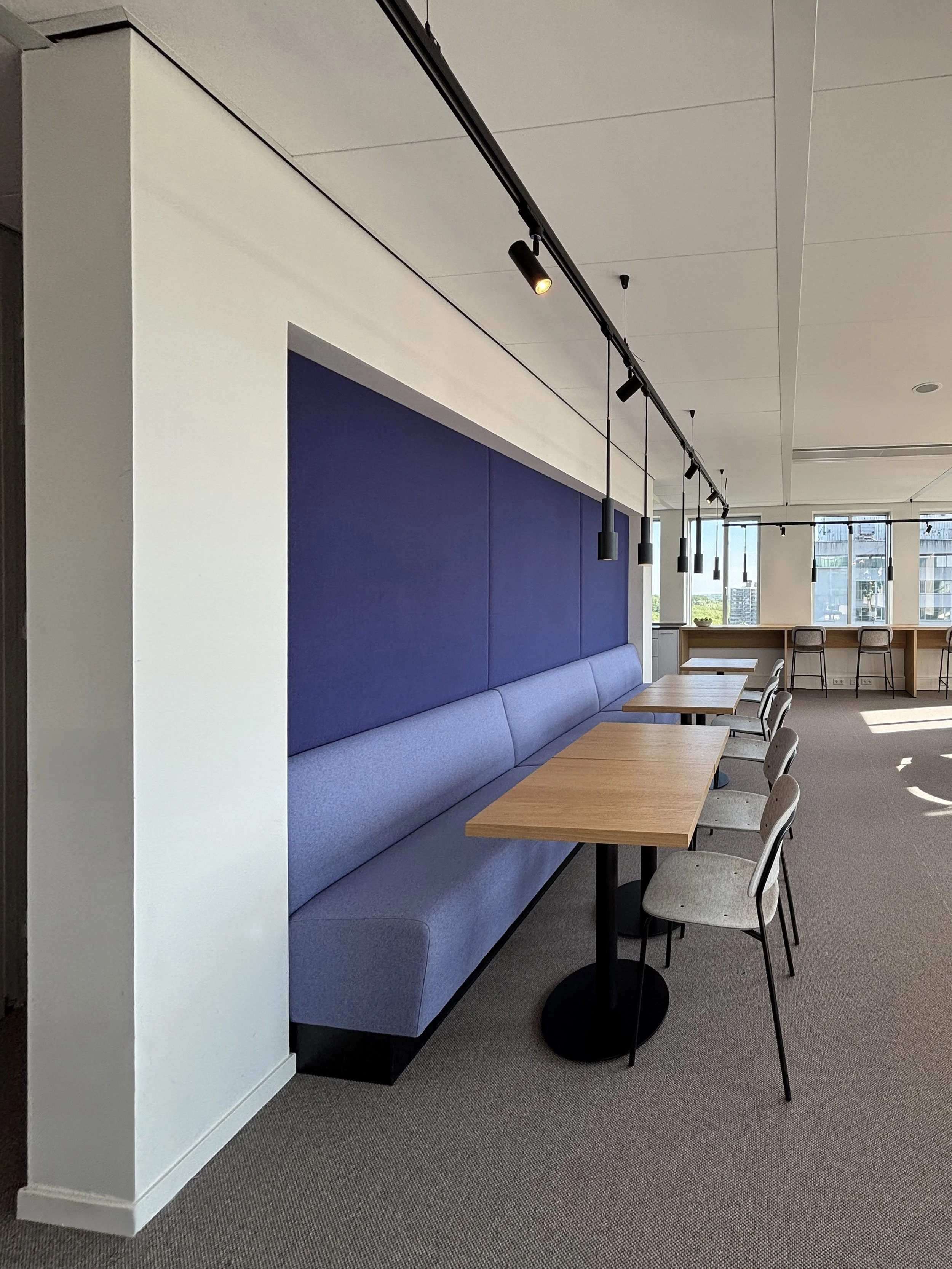 Office café with blue sofa seating at Garbe Institutional, Zuidas Amsterdam, designed by Meeder Ontwerpers.