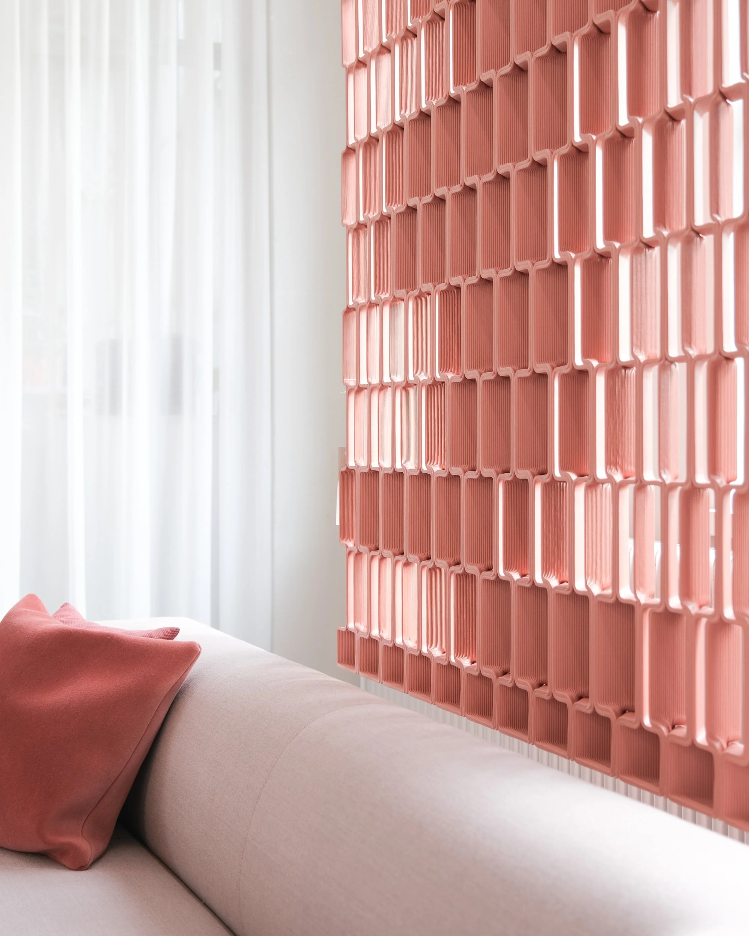 Nazka Screen, terra-cotta 3D printed circular room divider beside sofa, designed by Meeder Ontwerpers X Studio Michiel Wijnen and produced by Aectual.