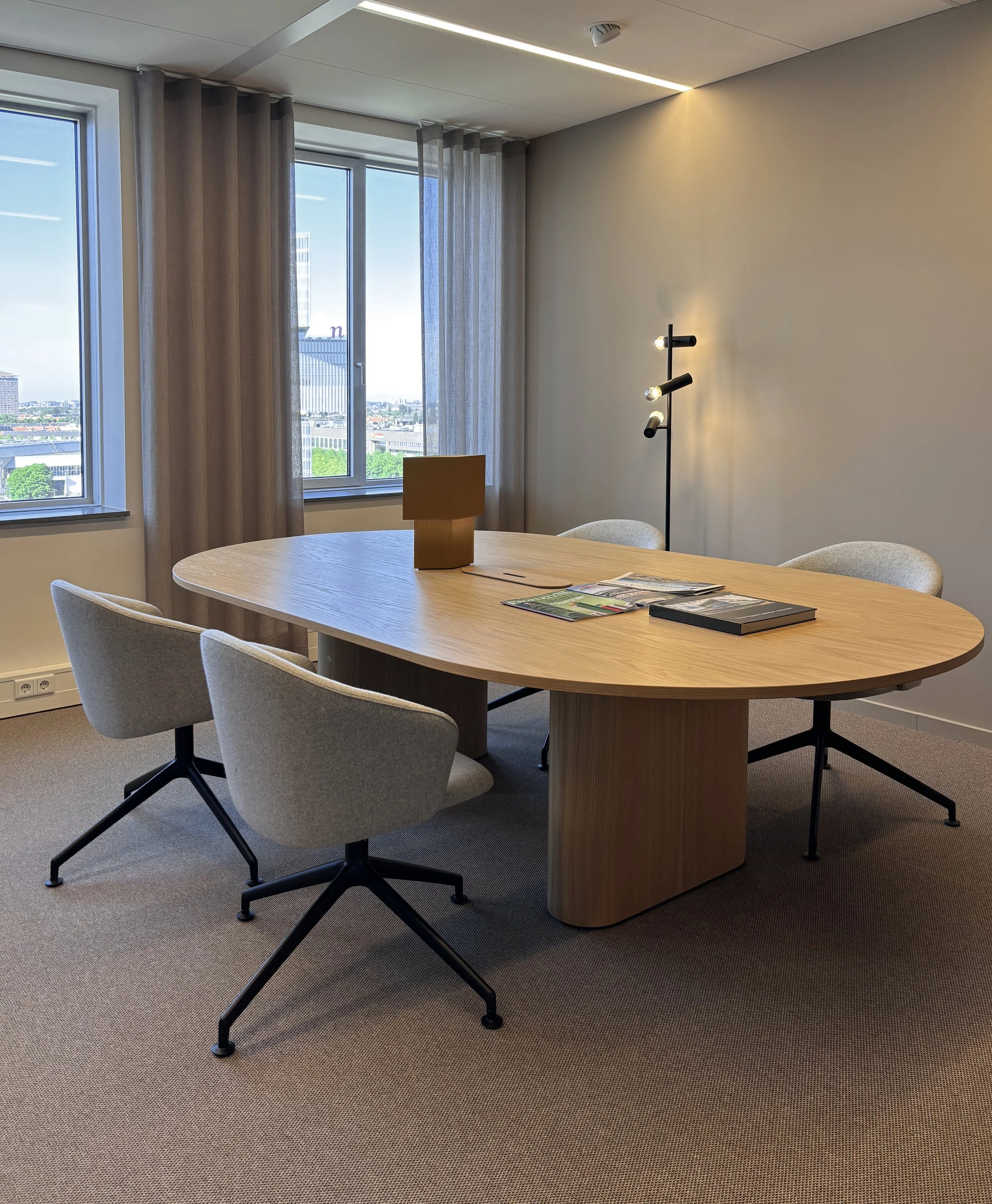 Reading table with view towards RAI and Amsterdam skyline at Garbe Institutional office, Zuidas Amsterdam, designed by Meeder Ontwerpers.