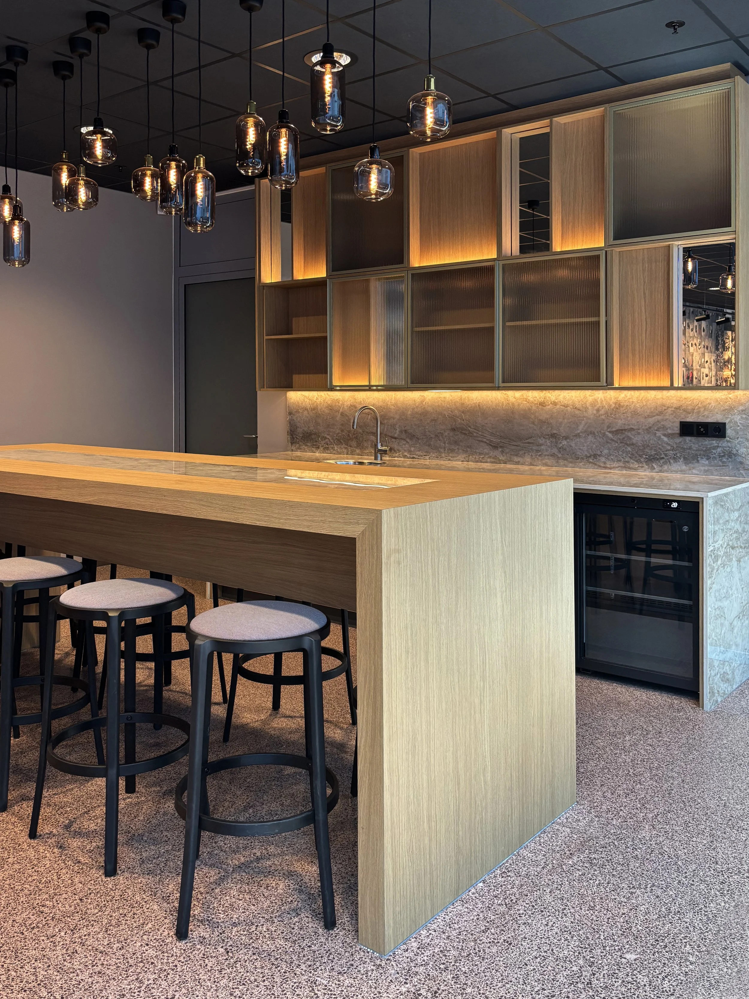 Bar interior with wood, natural stone and glass lighting in Rabo Lounge at Rabobank Headquarters Utrecht, designed by Meeder Ontwerpers X OIII Architecten.
