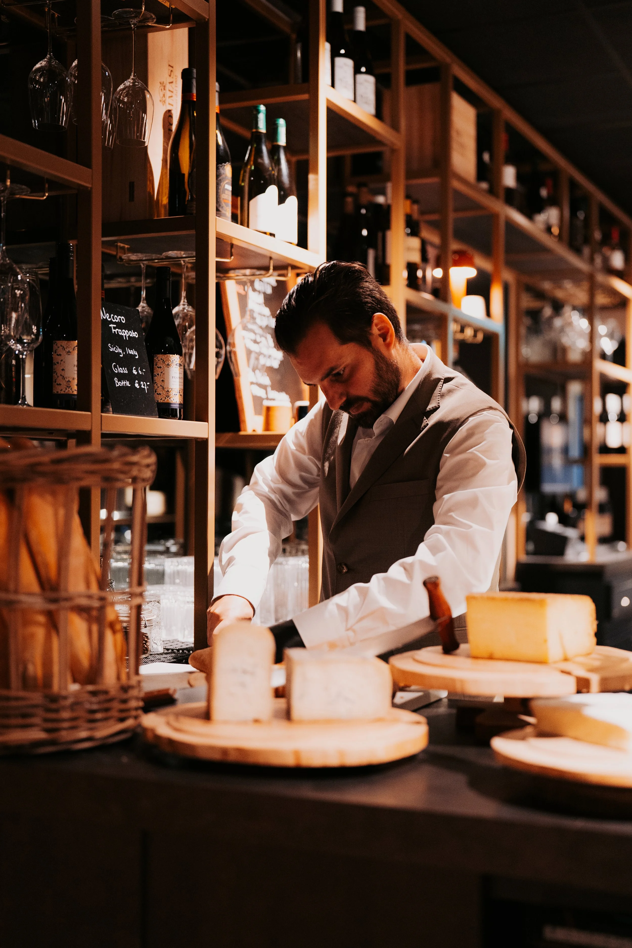 Cheese platter and waiter at wine bar in Vermeers Wijnkamer, NH Barbizon Palace Amsterdam, redesigned by Meeder Ontwerpers X Studio Michiel Wijnen.