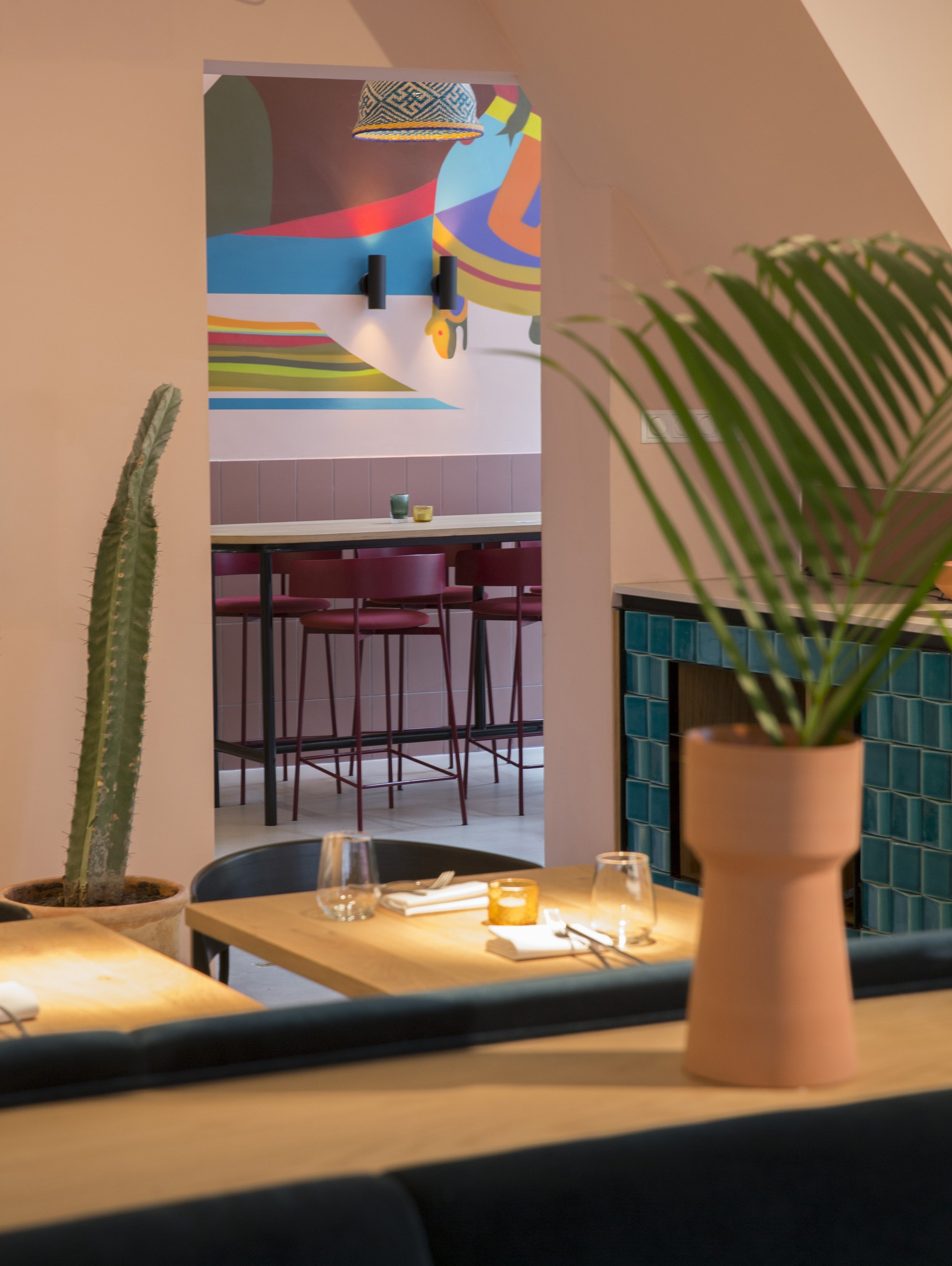 View through interior with cactus and pink wall at Restaurant Nazka, Amsterdam.. Designed by Meeder Ontwerpers