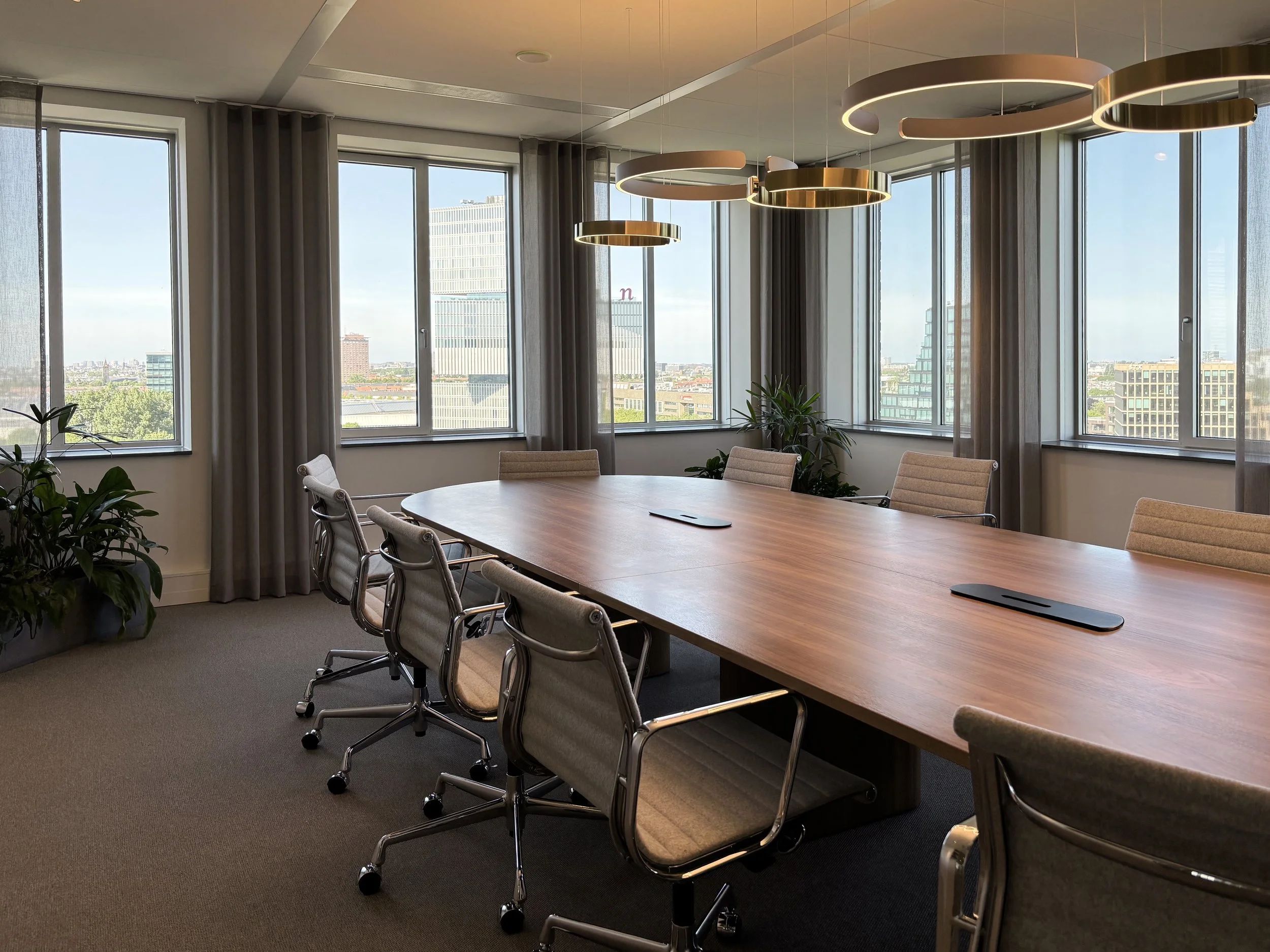 Boardroom with Vitra chairs, Kami table and gold pendant lamps at Garbe Institutional, Zuidas Amsterdam, designed by Meeder Ontwerpers.