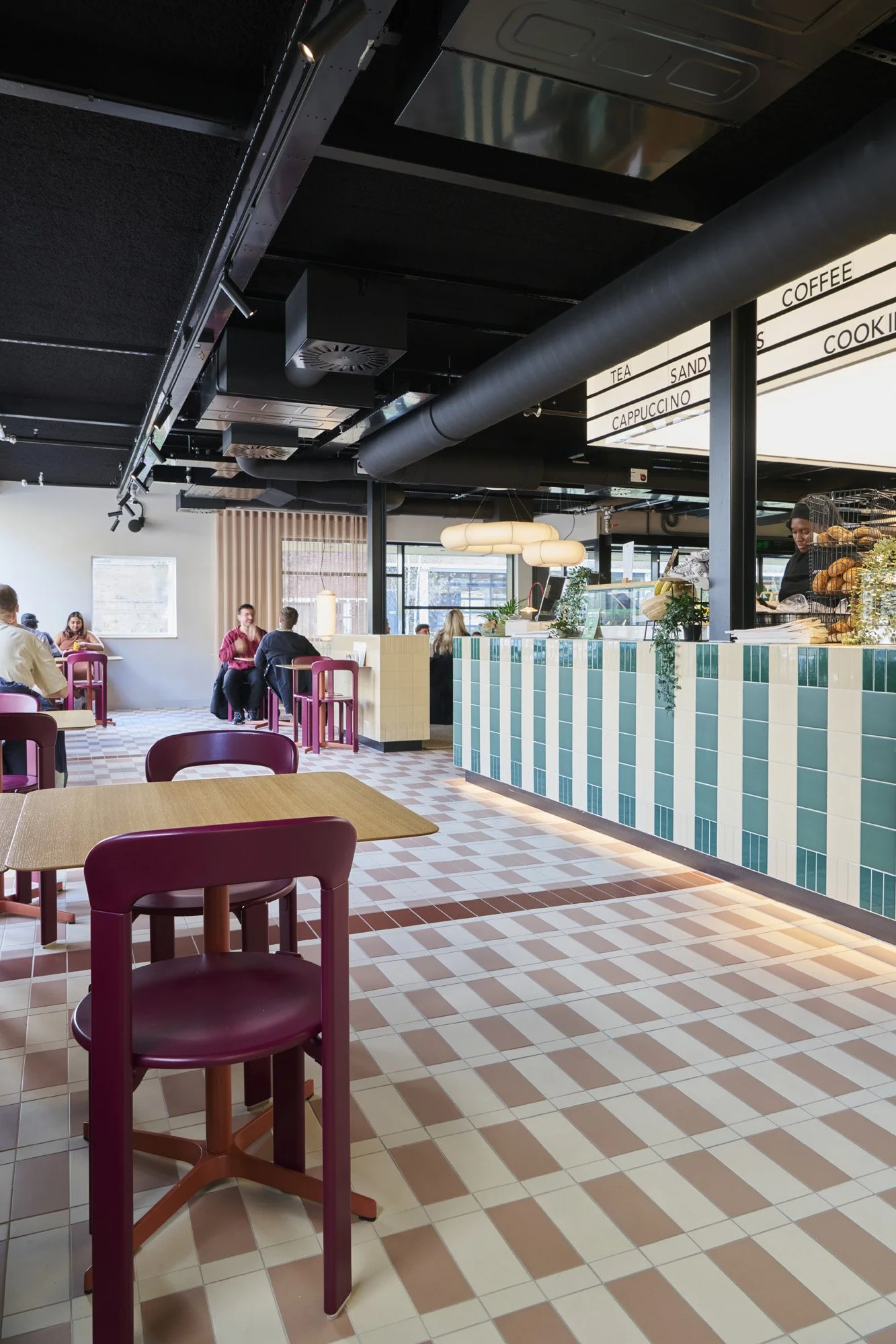 KBF Warehouse café featuring dining chairs, striped counter and backlit lightbox, Amsterdam.