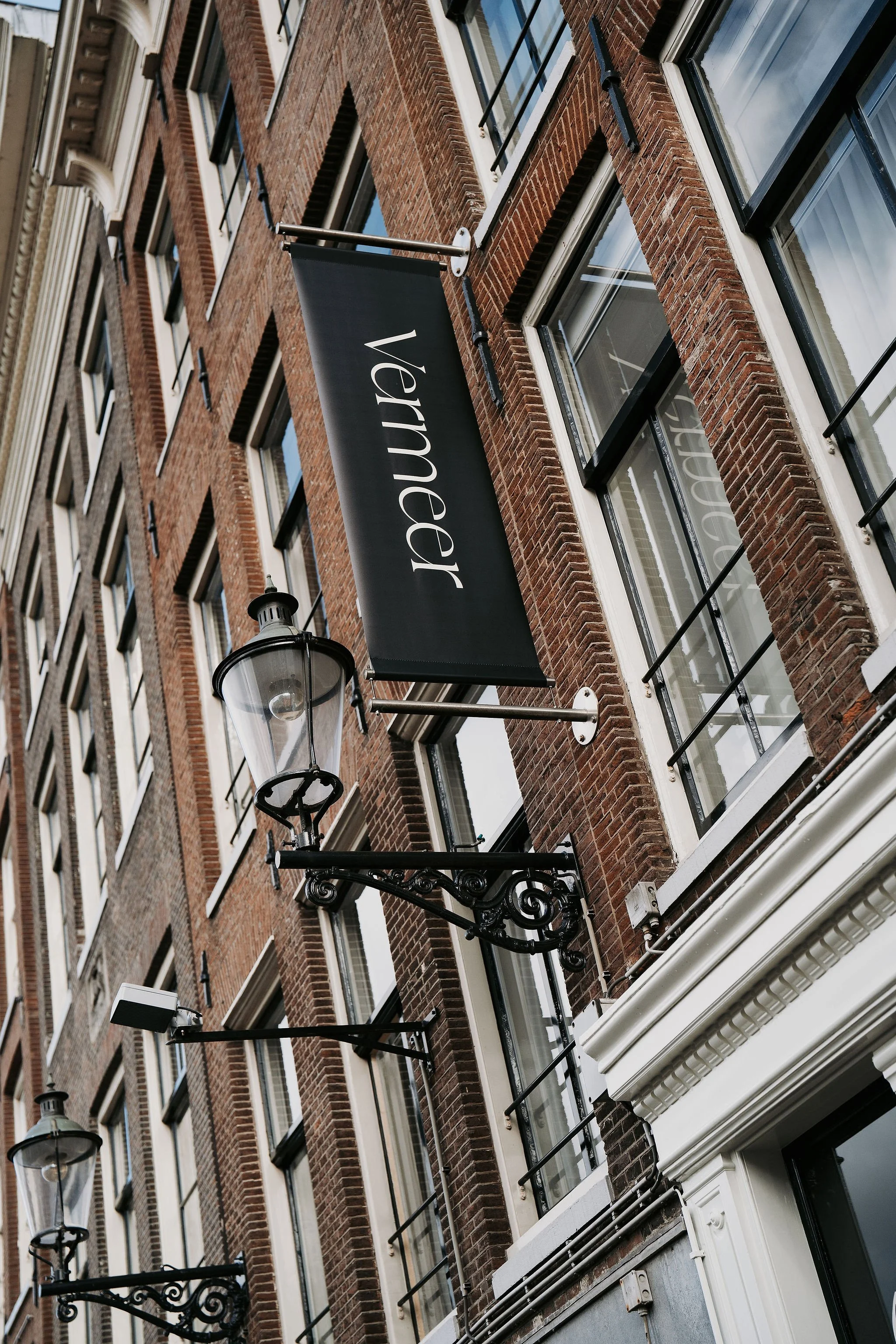 Facade banner with Restaurant Vermeer logo in Amsterdam, redesigned by Meeder Ontwerpers.