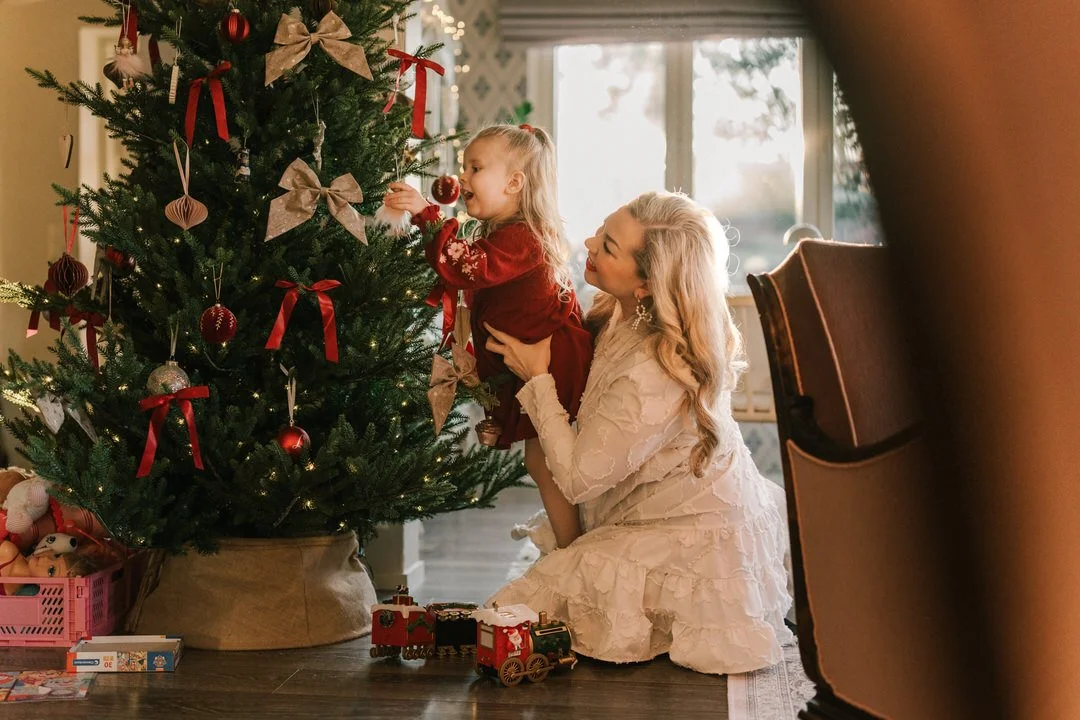 Perhekuvaus kotona Raisiossa. Äiti ja lapsi koristelee joulukuusta.