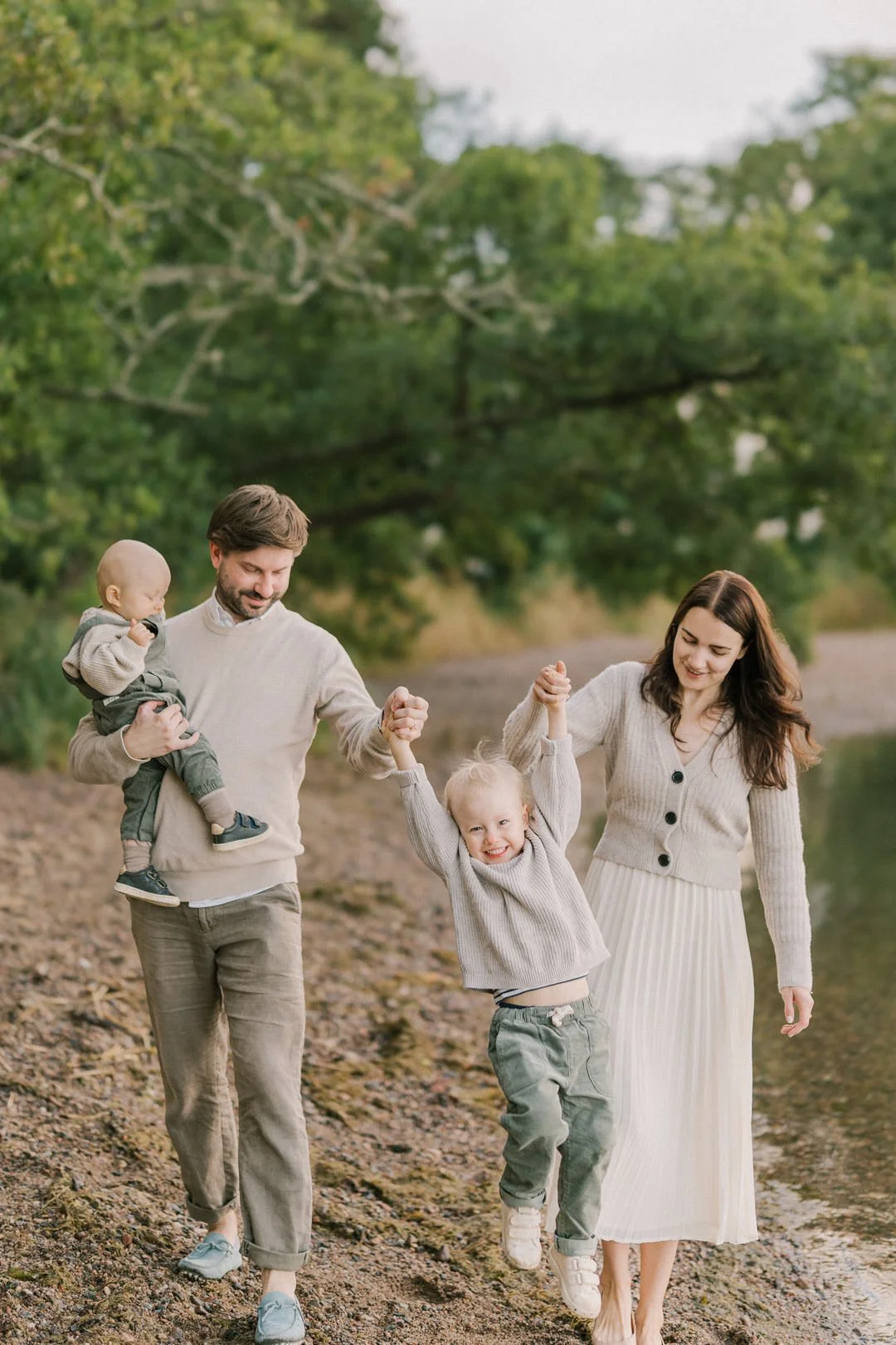 Pikkulapsiperhe rannalla perhekuvauksessa leikkimässä. Perhekuvaus Turussa.