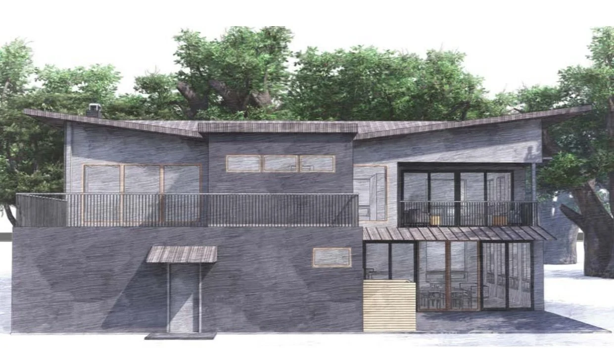 Modern gray two-story house with large windows and a balcony, surrounded by trees.