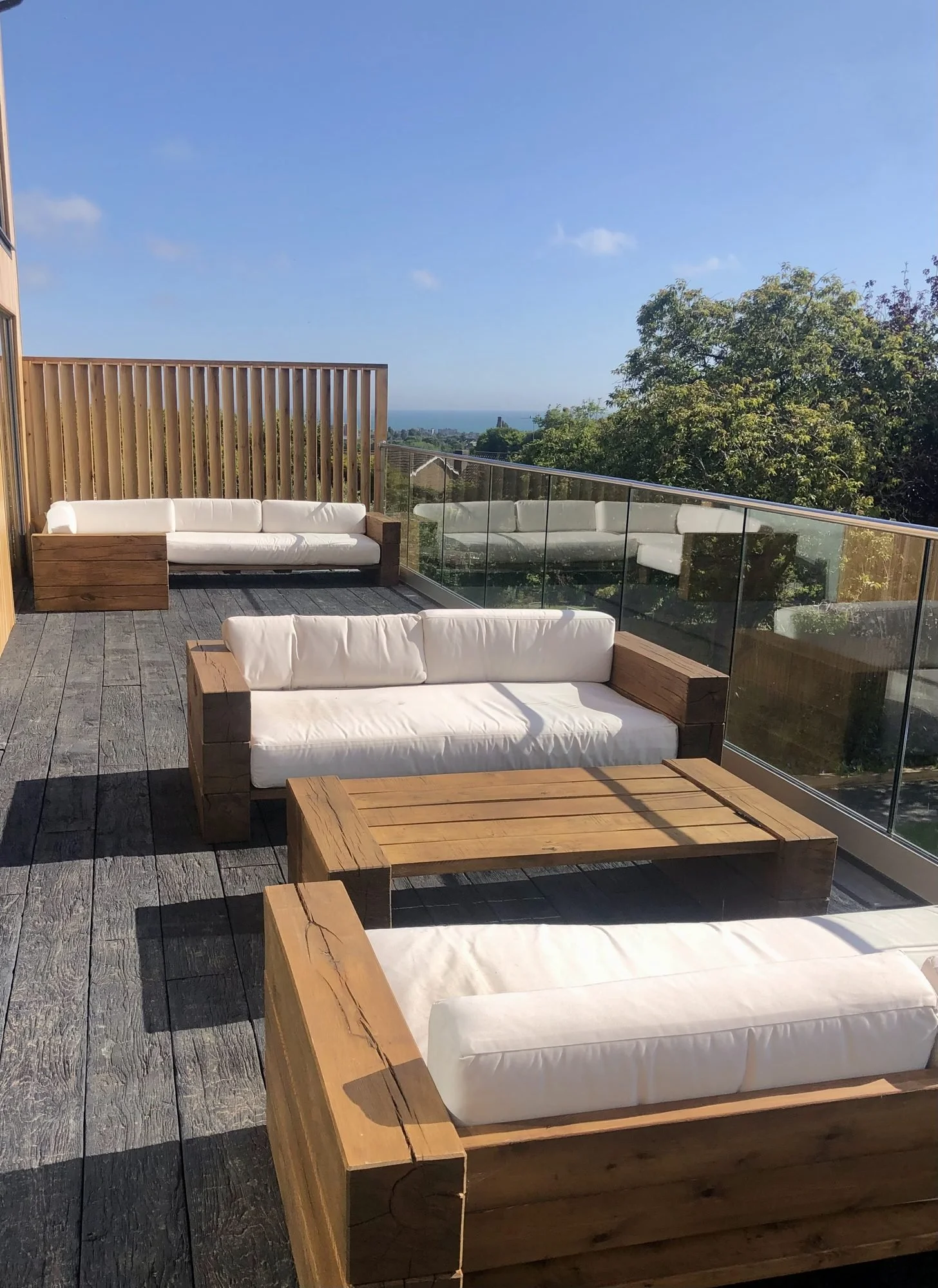 Bespoke oak sofas and coffee table on Millboard decking with sea view, Hove