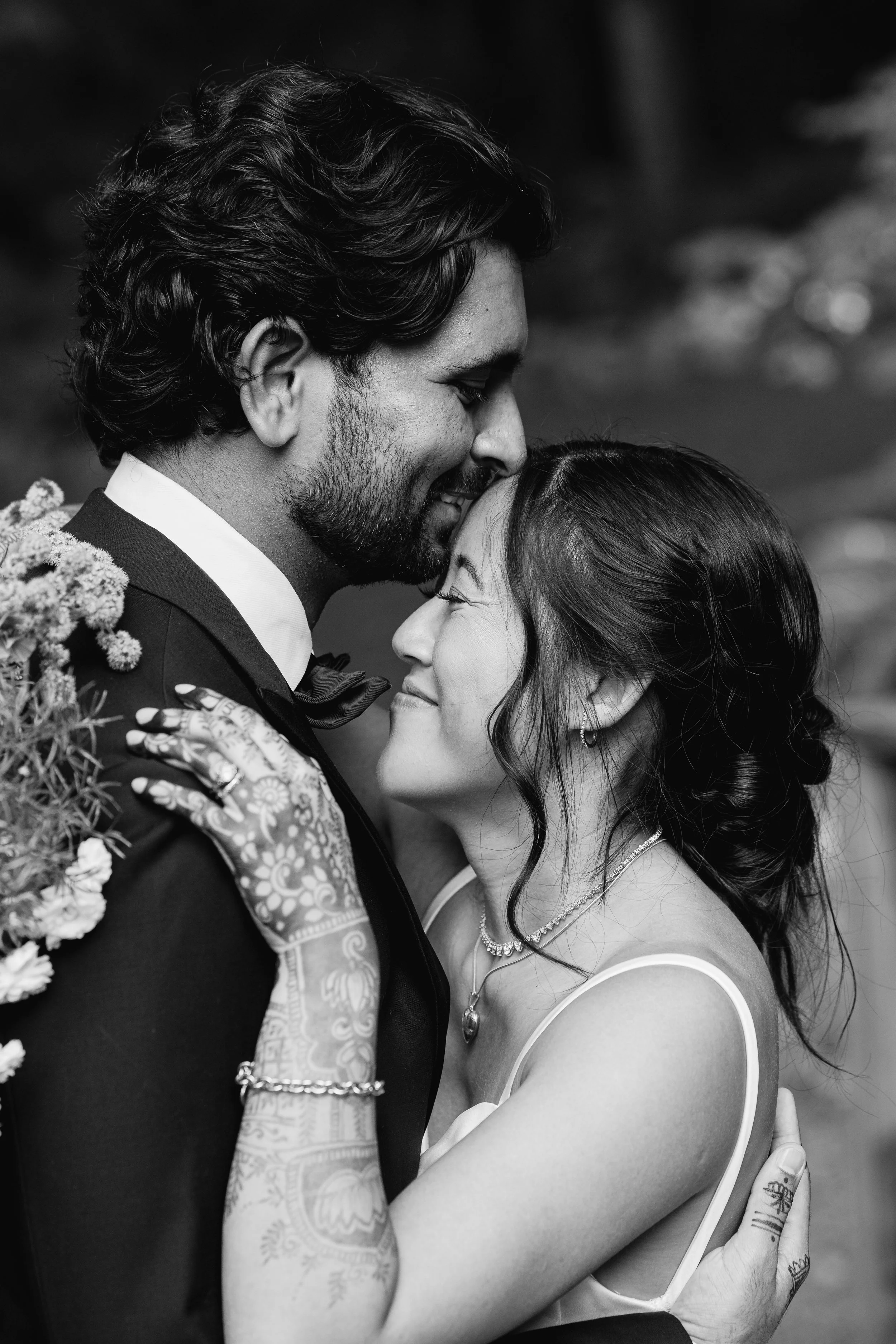 A black and white photo of a couple embracing outdoors, with their foreheads touching and eyes closed, smiling. Traditional Indian wedding, oregon wedding, california wedding bay area wedding portland wedding rural wedding best wedding photographer