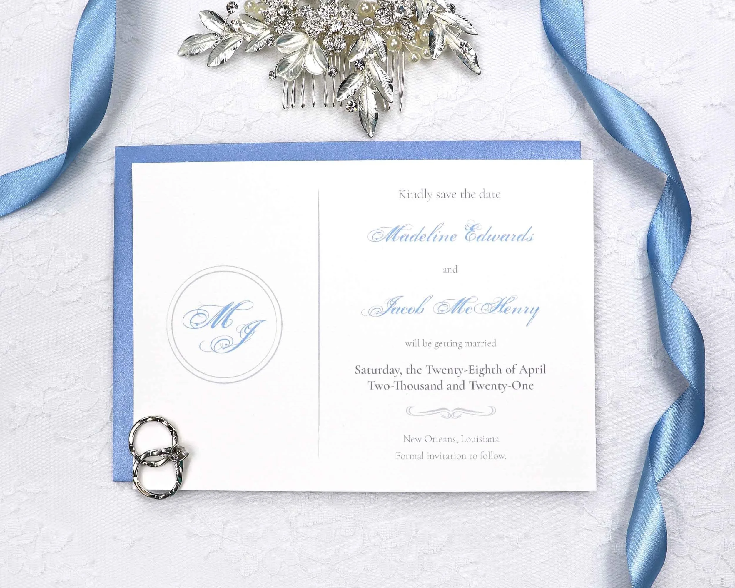 Simple and elegant save the date featuring a script font wedding monogram and light blue and silver colors.