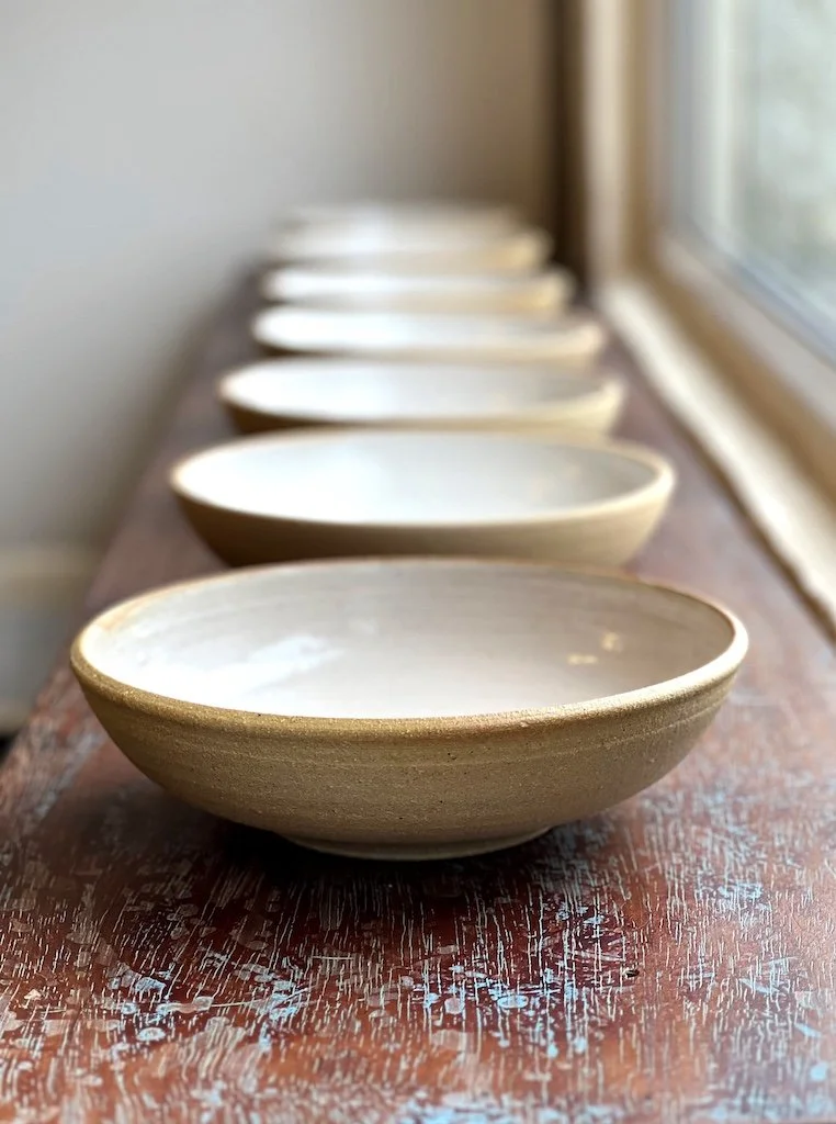 Row of ceramic bowls on a wooden surface