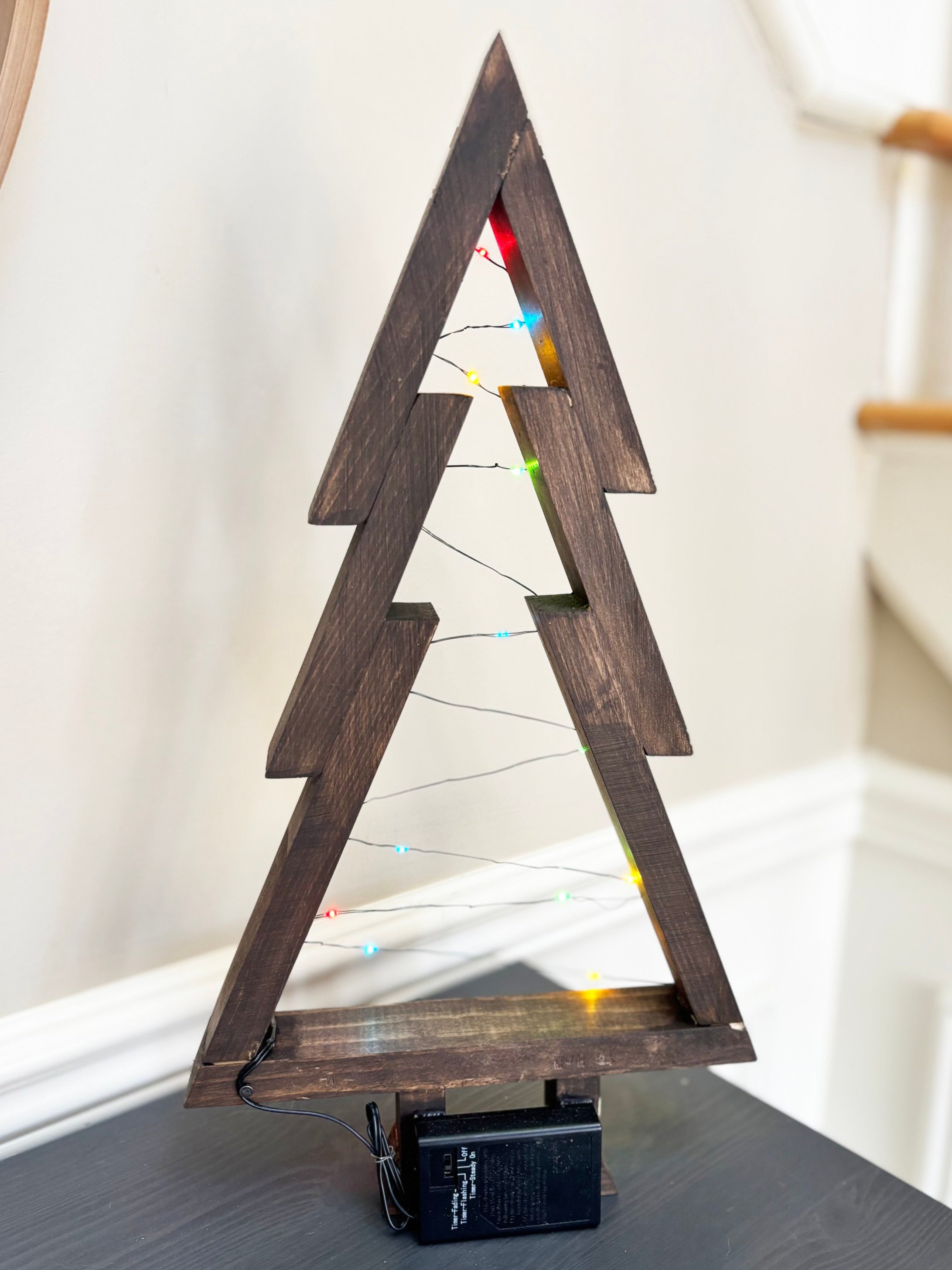 Handmade 17-inch stained pine Christmas tree with 18 multicolor slim wire lights.