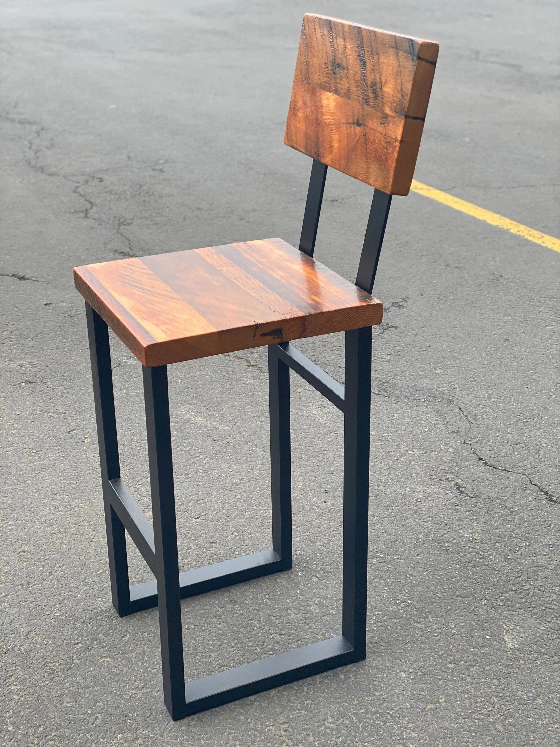 wooden bar stool with metal frame on pavement