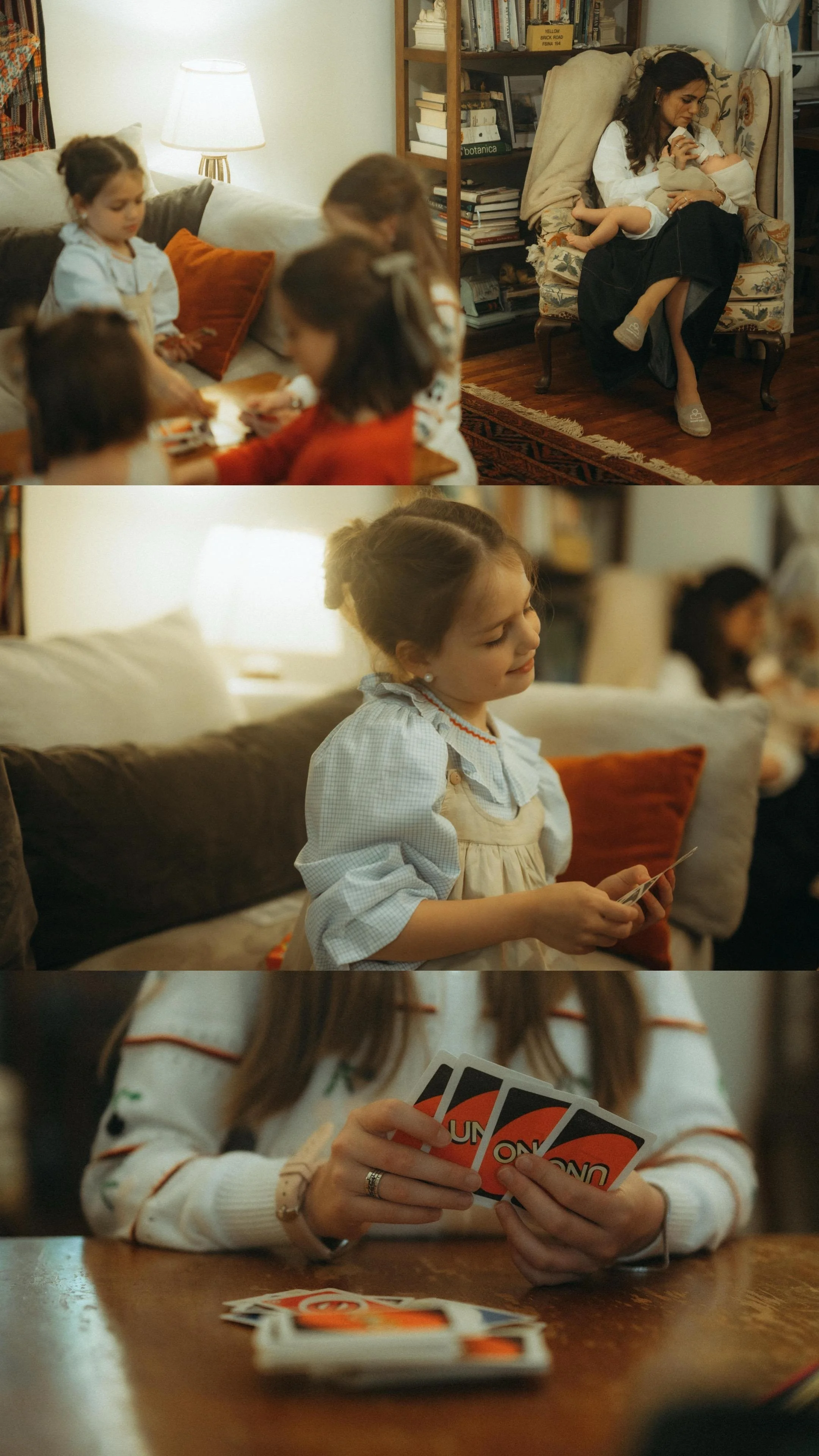 A family playing Uno card game together in a cozy living room, with children and an adult woman, some children sitting on a sofa, others standing or sitting, and one girl holding cards at the table.