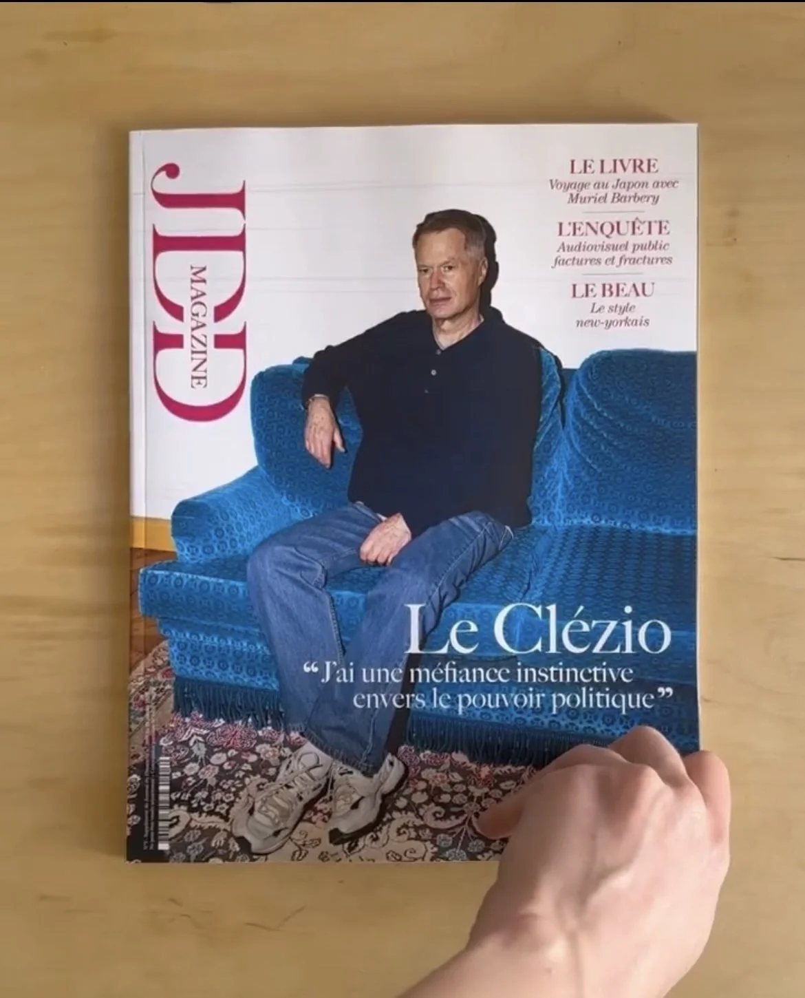 Cover of Guider magazine featuring a man sitting on a blue couch, dressed casually in jeans and sneakers, with a quote in French.