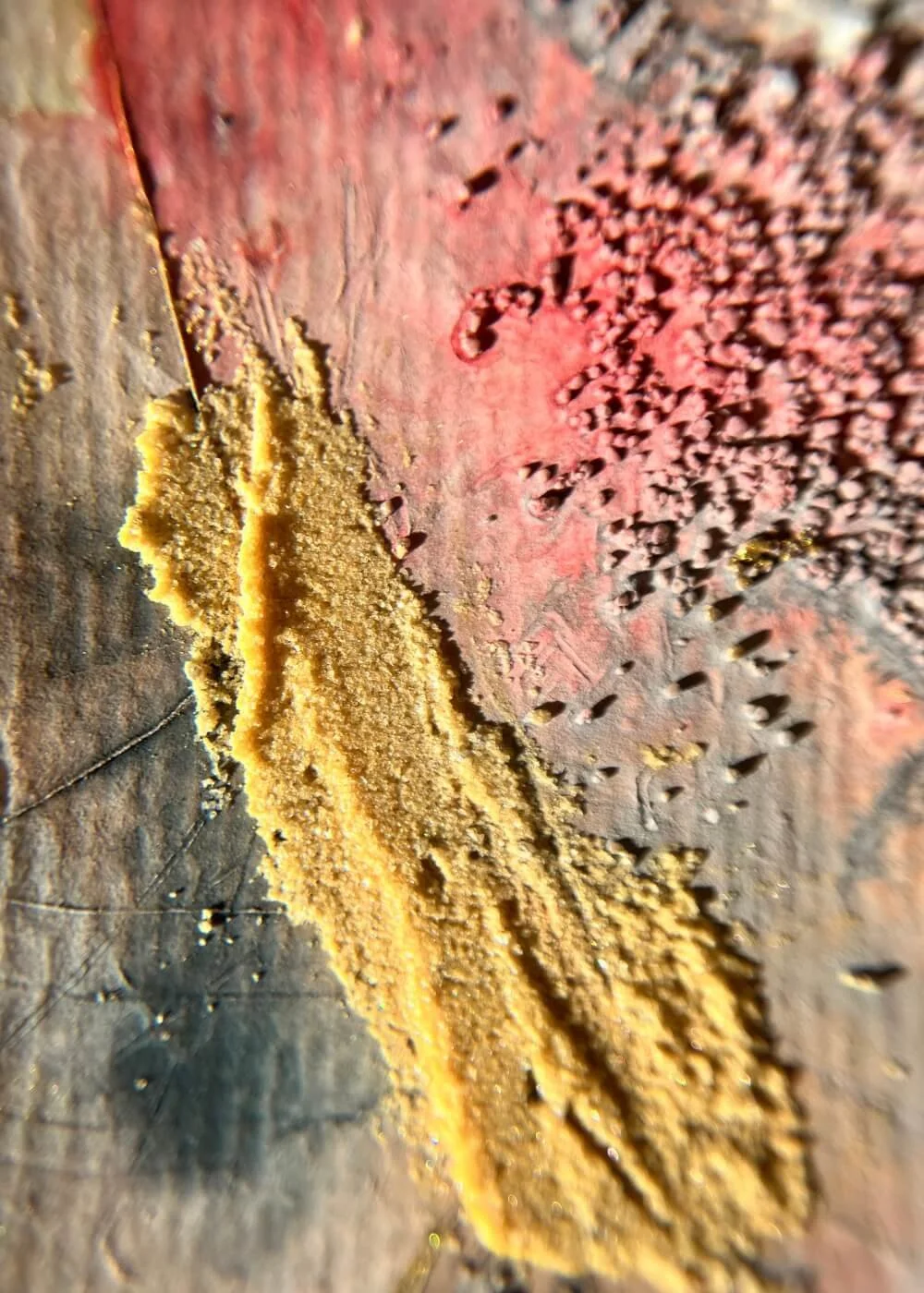 Fragments of pigment and rough relief shimmer under soft light — where gold met the rage, transformation found its form.