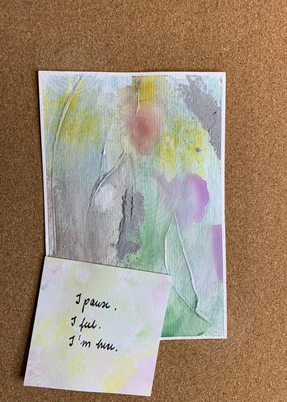 Abstract artwork "Between the Seconds No. 2" in pastel green, lilac, and yellow with an affirmation card reading “I pause. I feel. I’m here.” placed in front.