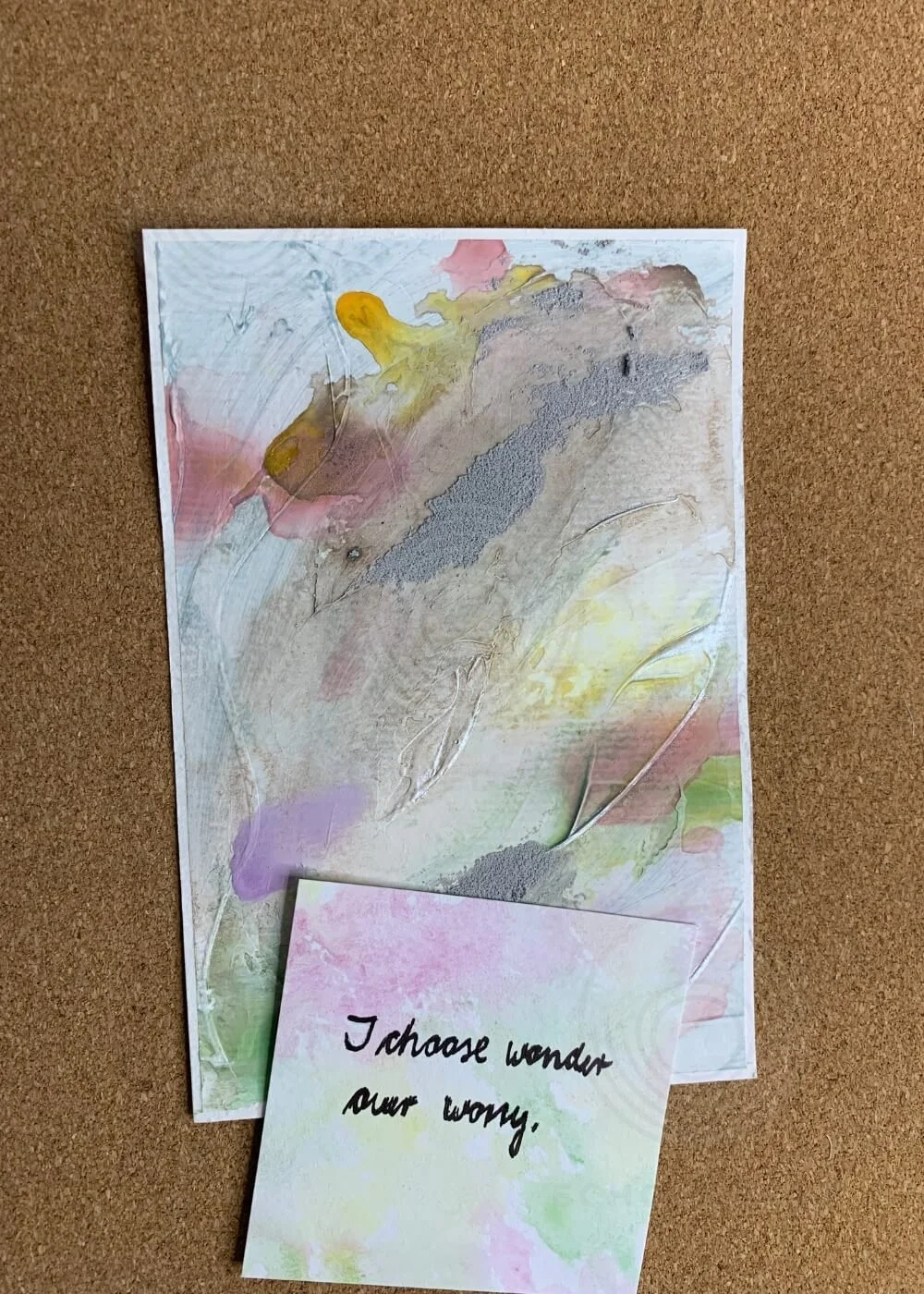 Abstract artwork Between the Seconds No. 5 with handwritten affirmation card reading “I choose wonder over worry.” on a cork background.