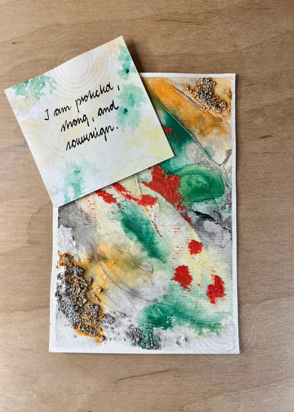 Textured abstract painting "Where I Draw the Line" with affirmation card reading "I am protected, strong, and sovereign" on wooden background.