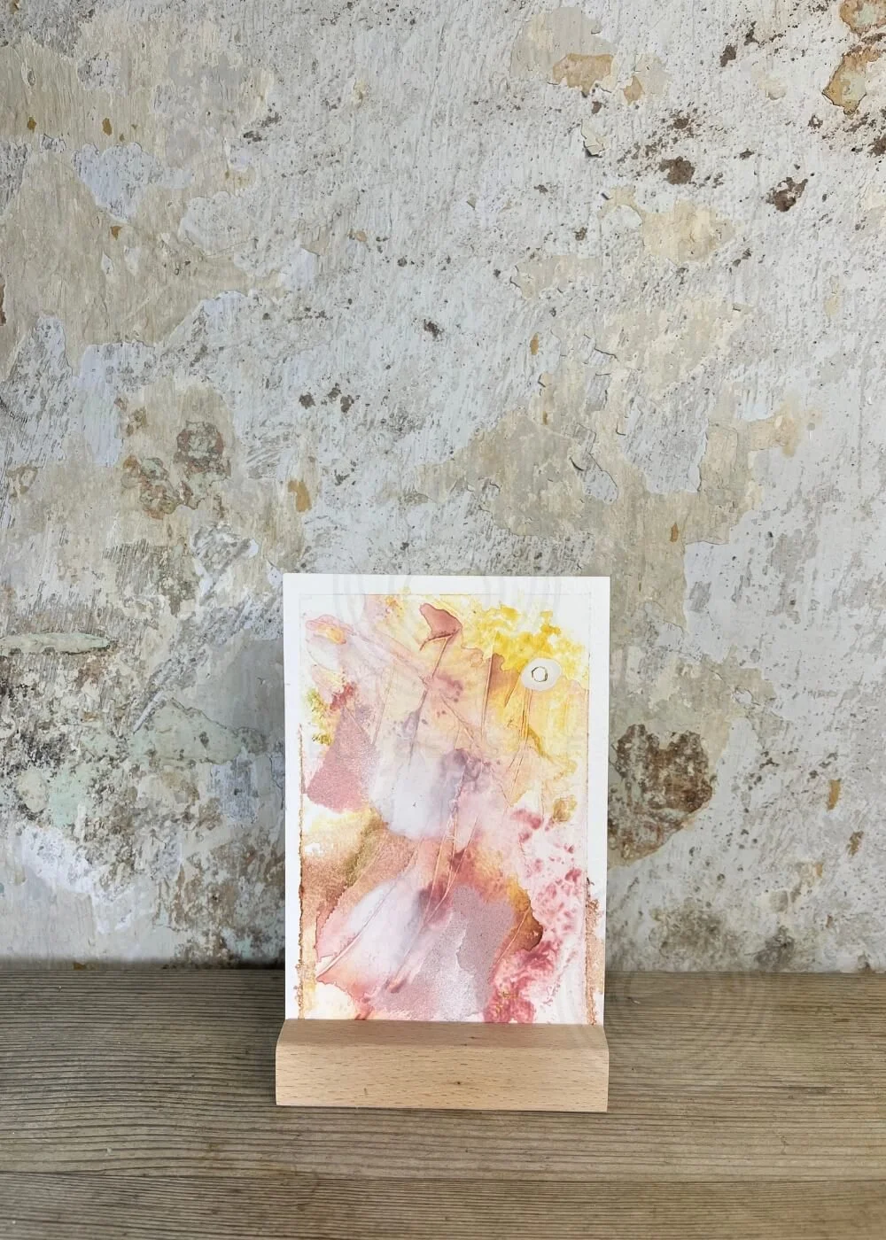“Held by Myself No. 7” – tactile healing artwork in warm rose, golden yellow, and earthy tones, displayed upright on a wooden stand.