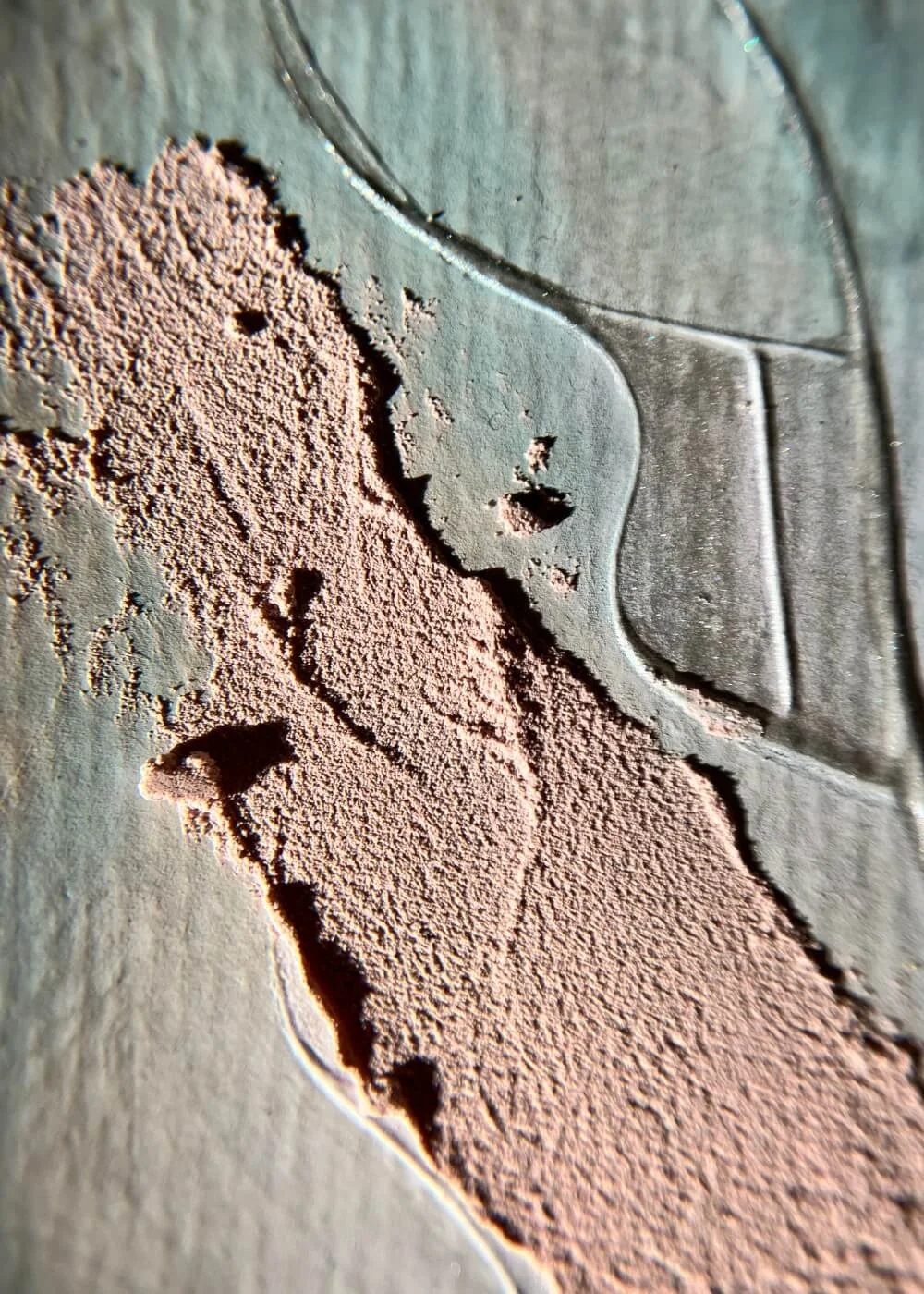 Macro detail showing tactile blush texture meeting soft blue surface — fine carved lines echo quiet breath and mindful stillness.
